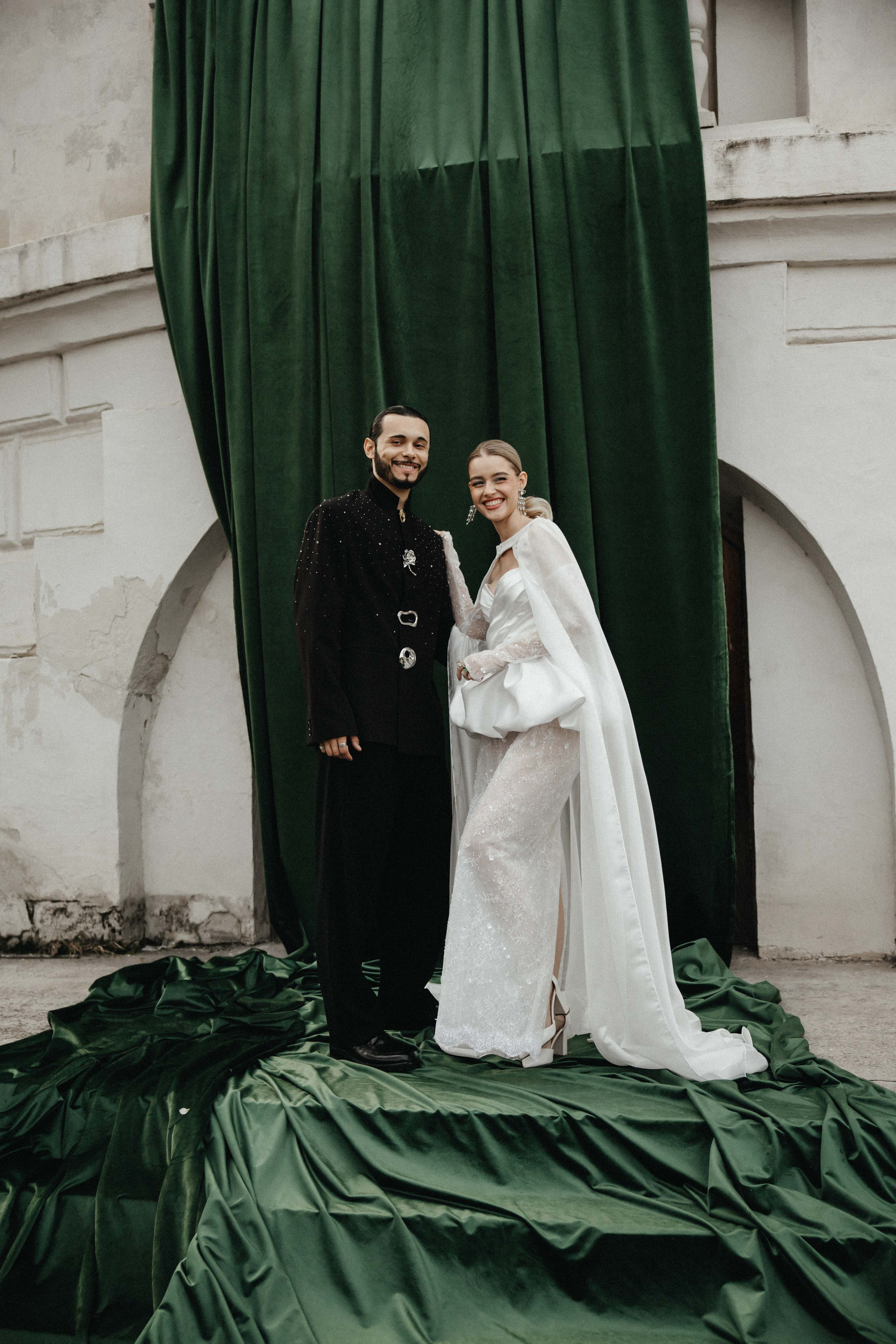 Счастливая пара позирует на свадебной фотосессии на фоне зеленой ткани в театре ,фэшн съемка ,топ 100 — свадебный фотограф Алена Межевова