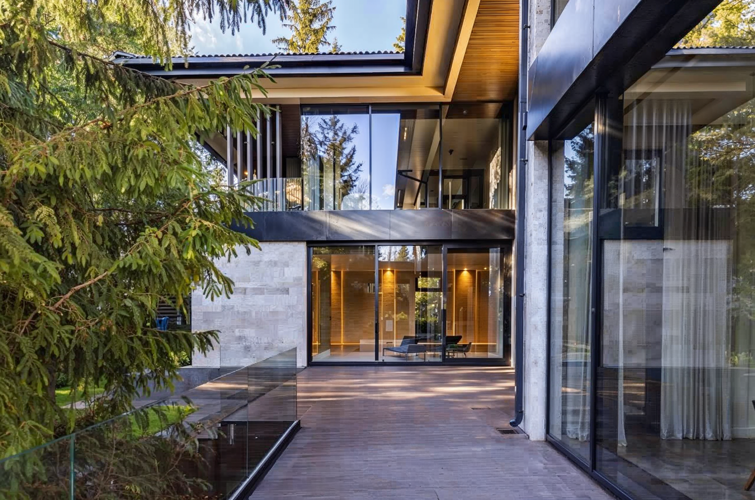 Современный фасад резиденции 1240 м² с панорамным остеклением, просторной террасой и видом на хвойный лес, архитектурный проект Валерии Котович.