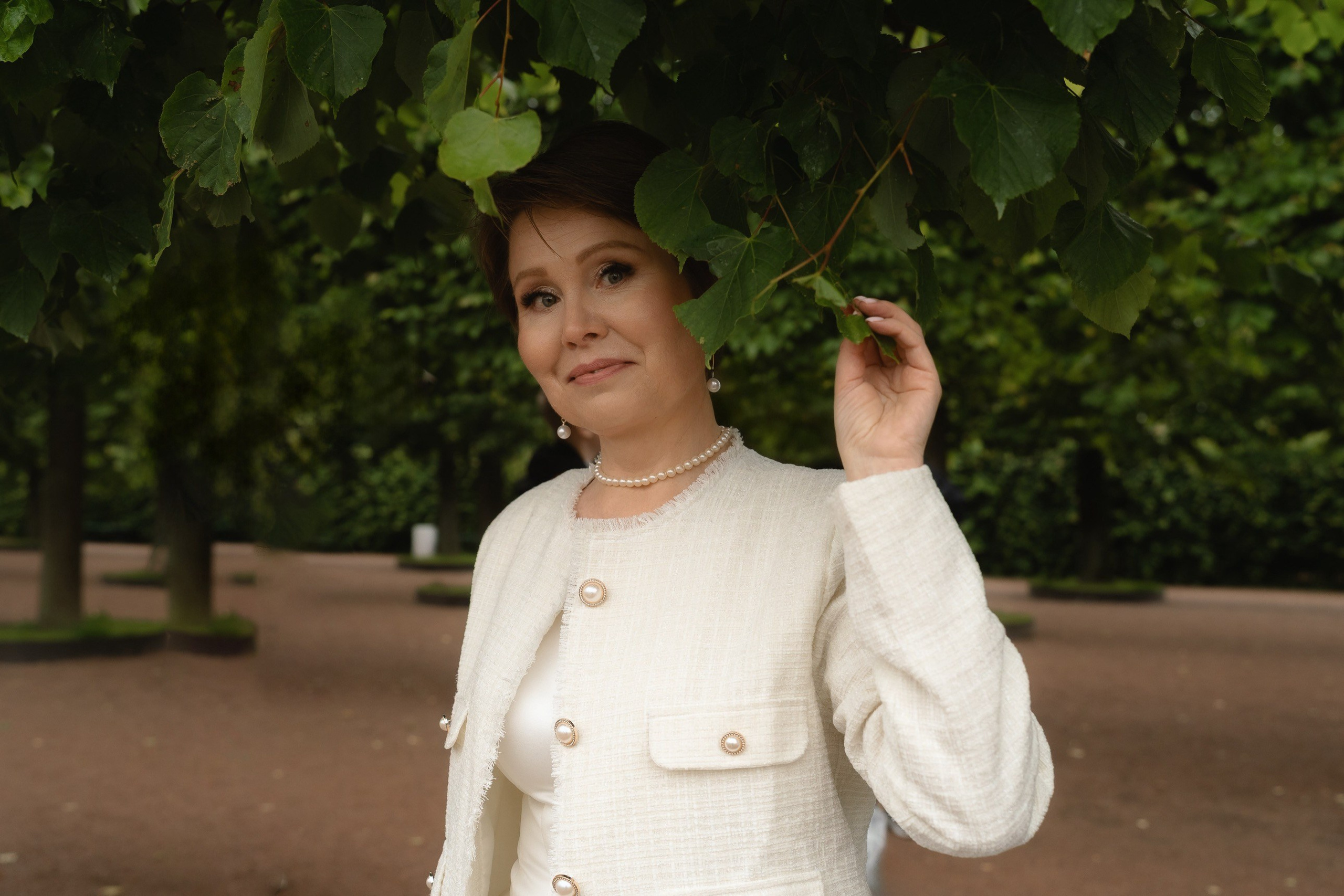 Портрет невесты в кремовом платье на фоне летней зелени