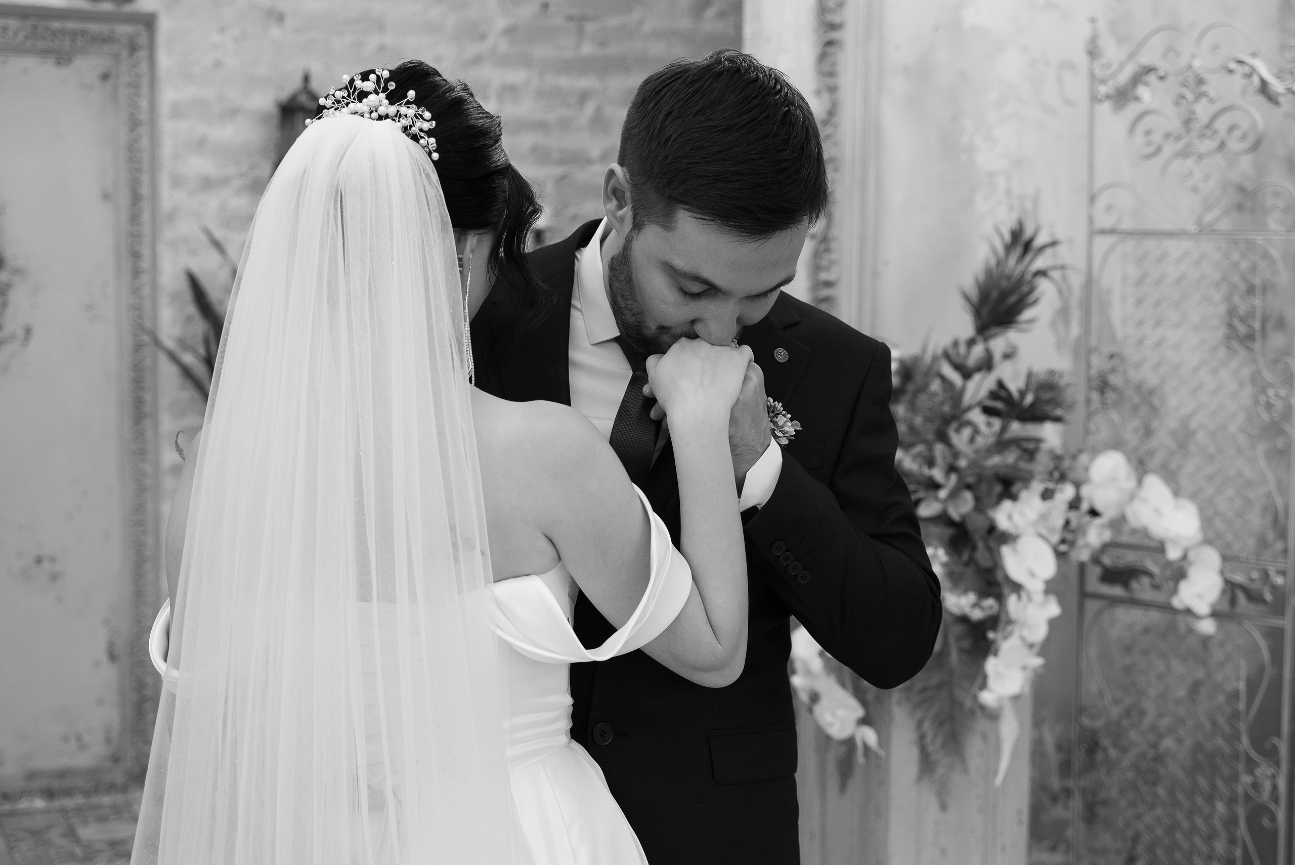 Жених целует невесту в поданную руку.