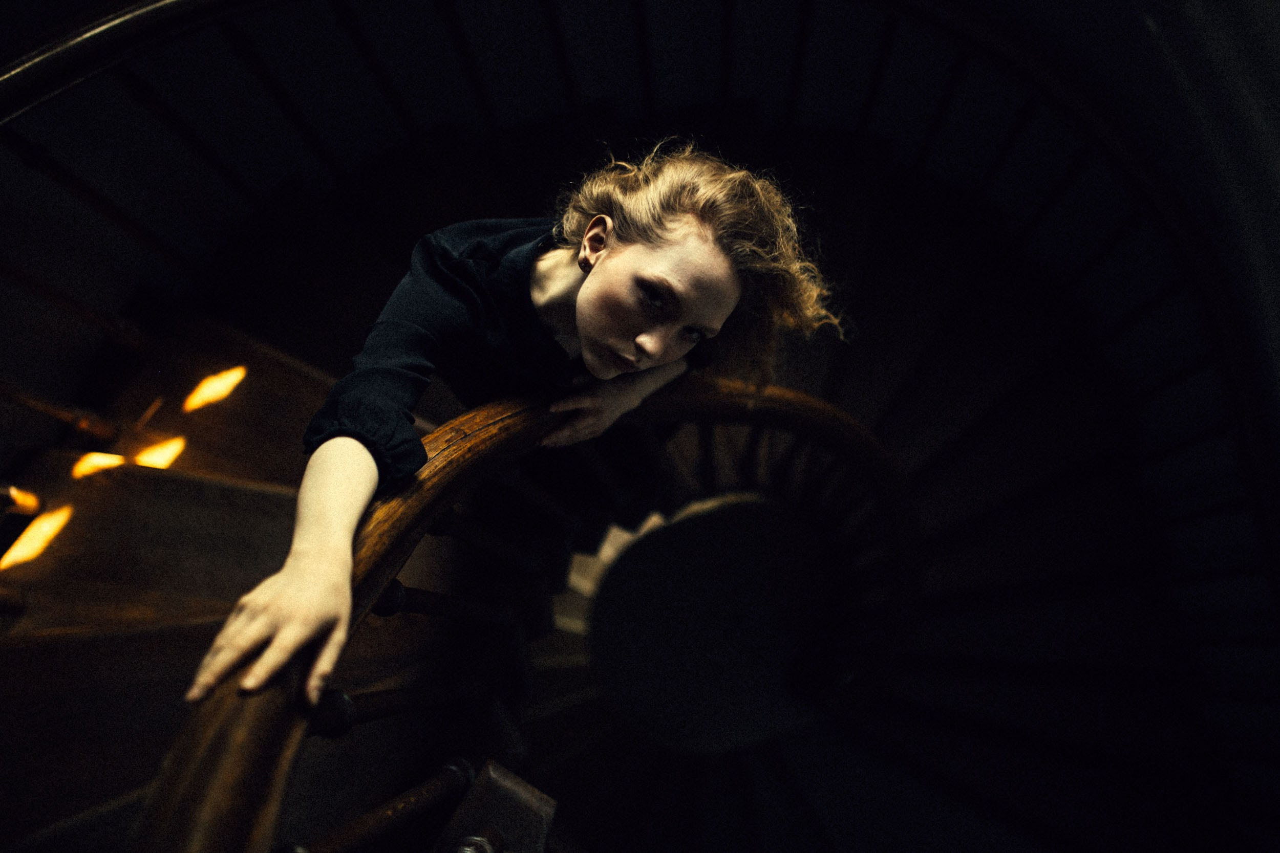 Девушка в черном платье на винтовой лестнице