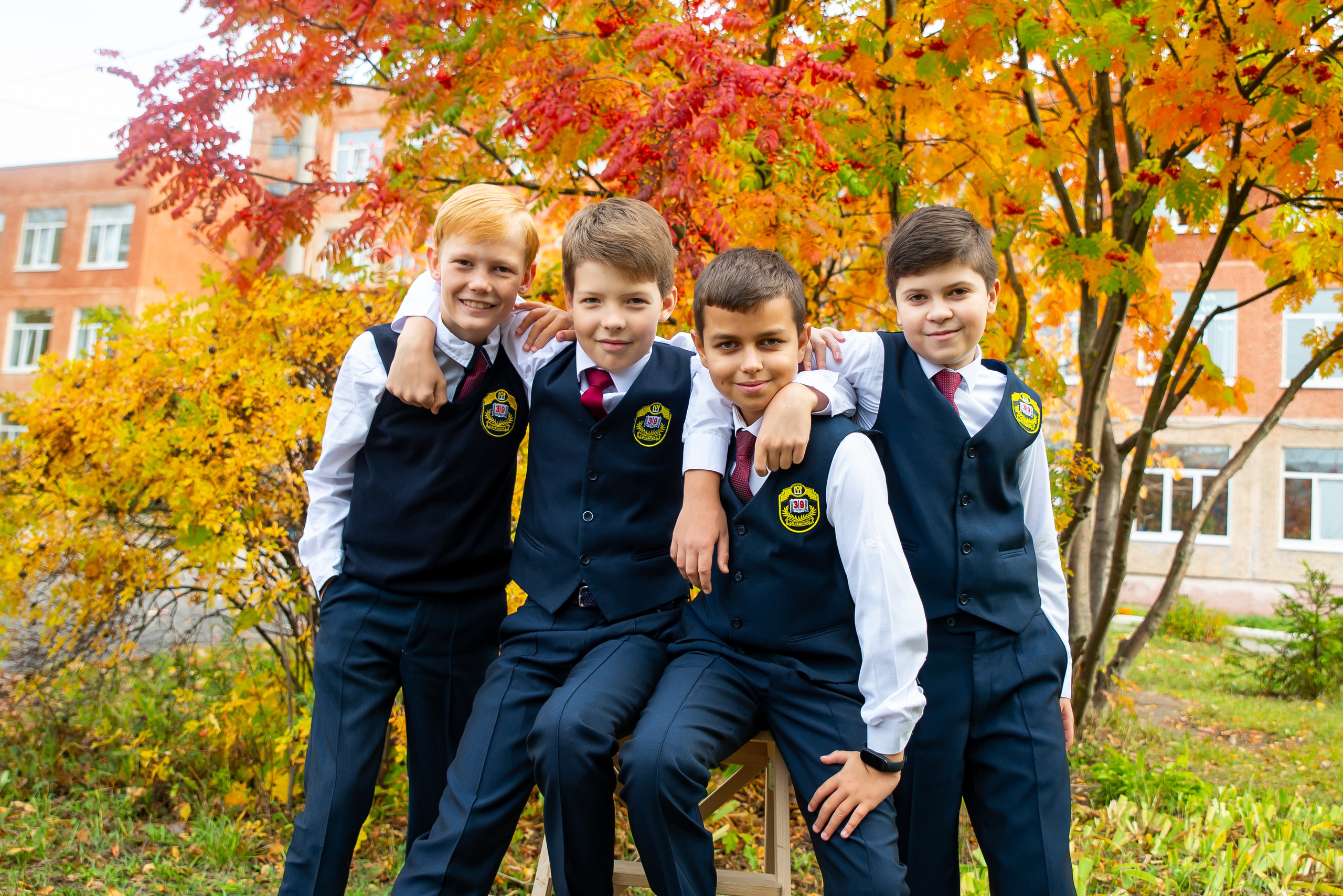 Школьники на фоне осенней рябины.