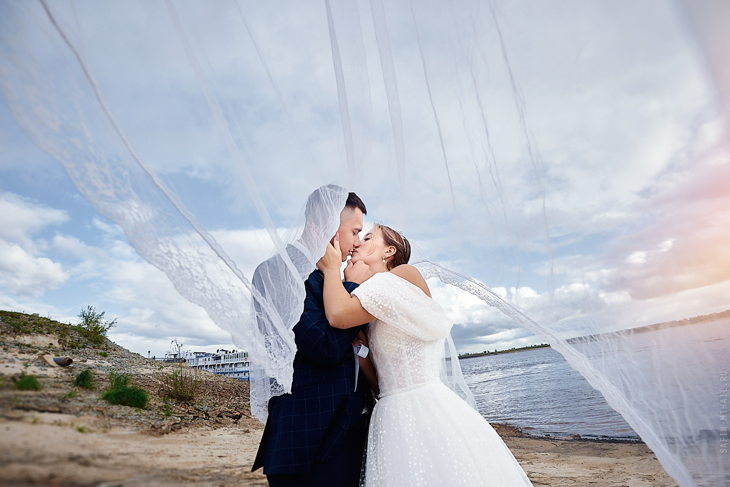 двое влюблённых молодожён и длинная свадебная фата