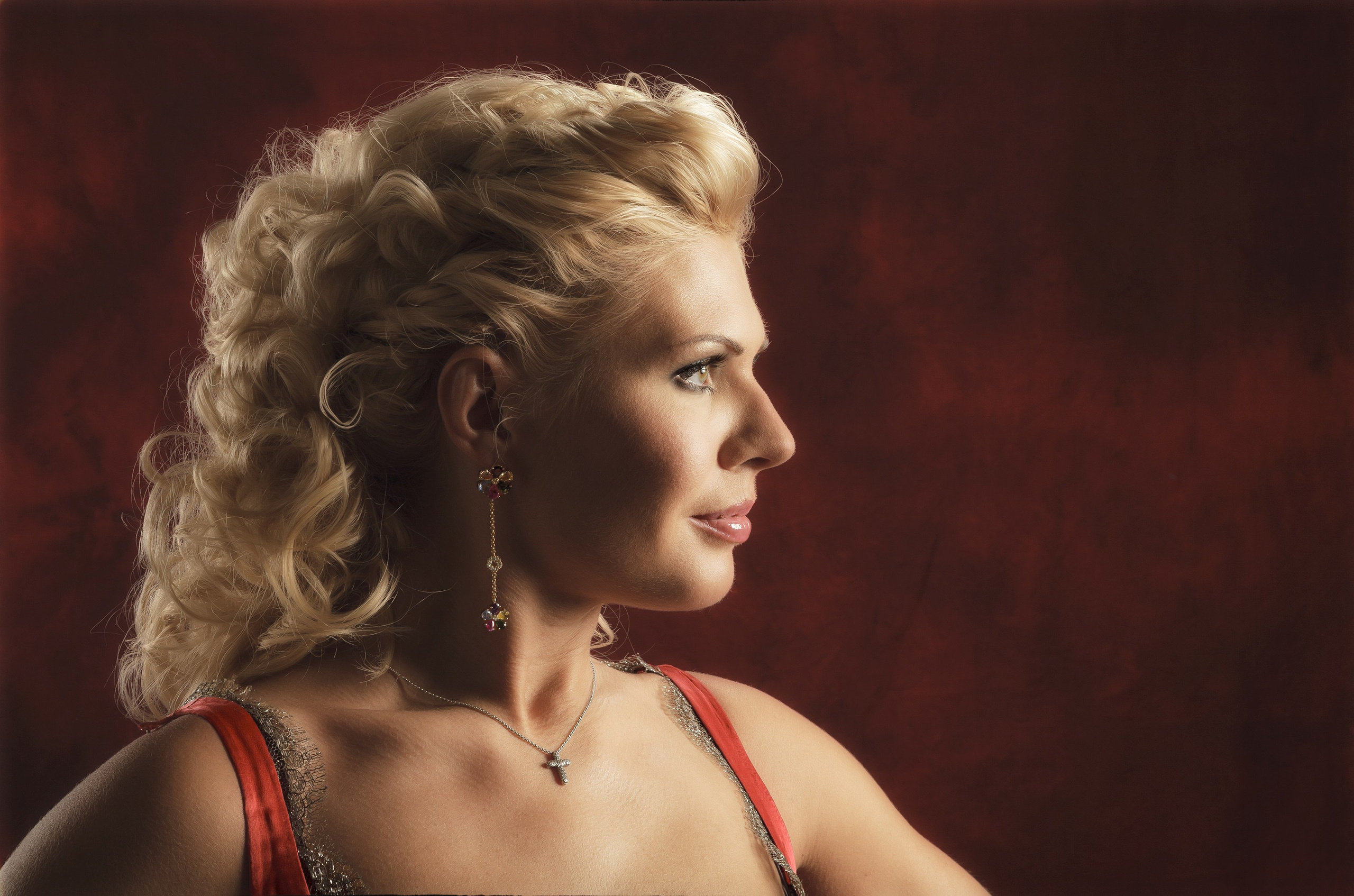 Студийный профильный портрет блондинки в красном.