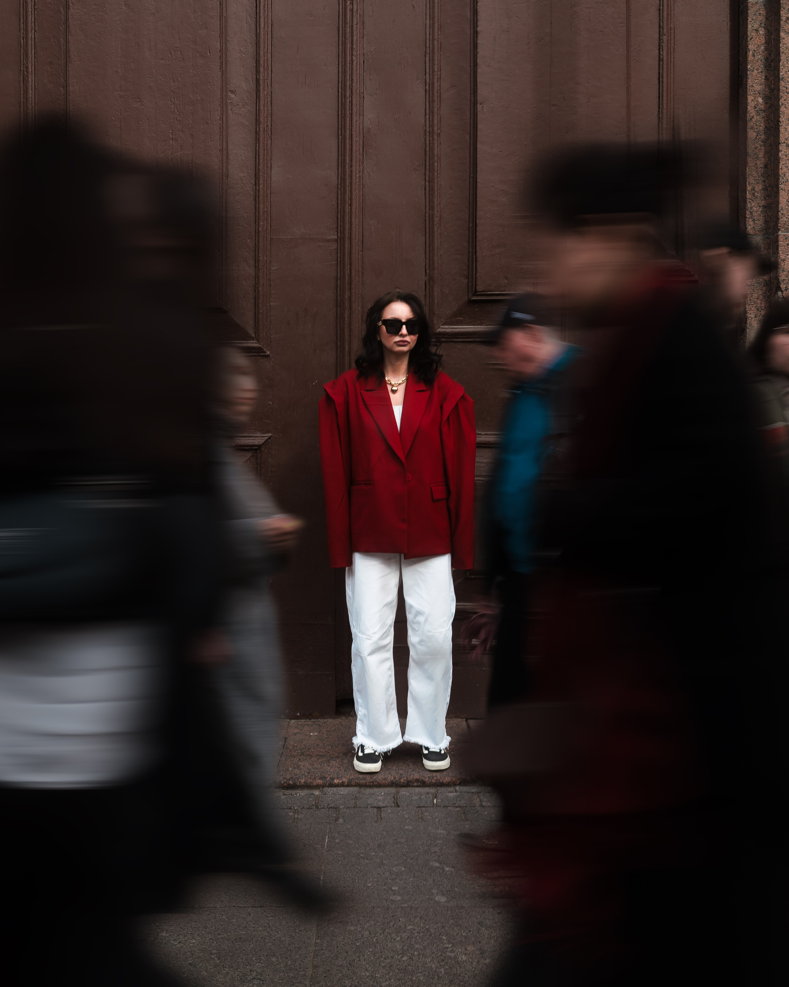 портрет девушки между проходящих прохожих на фоне питерской исторической двери