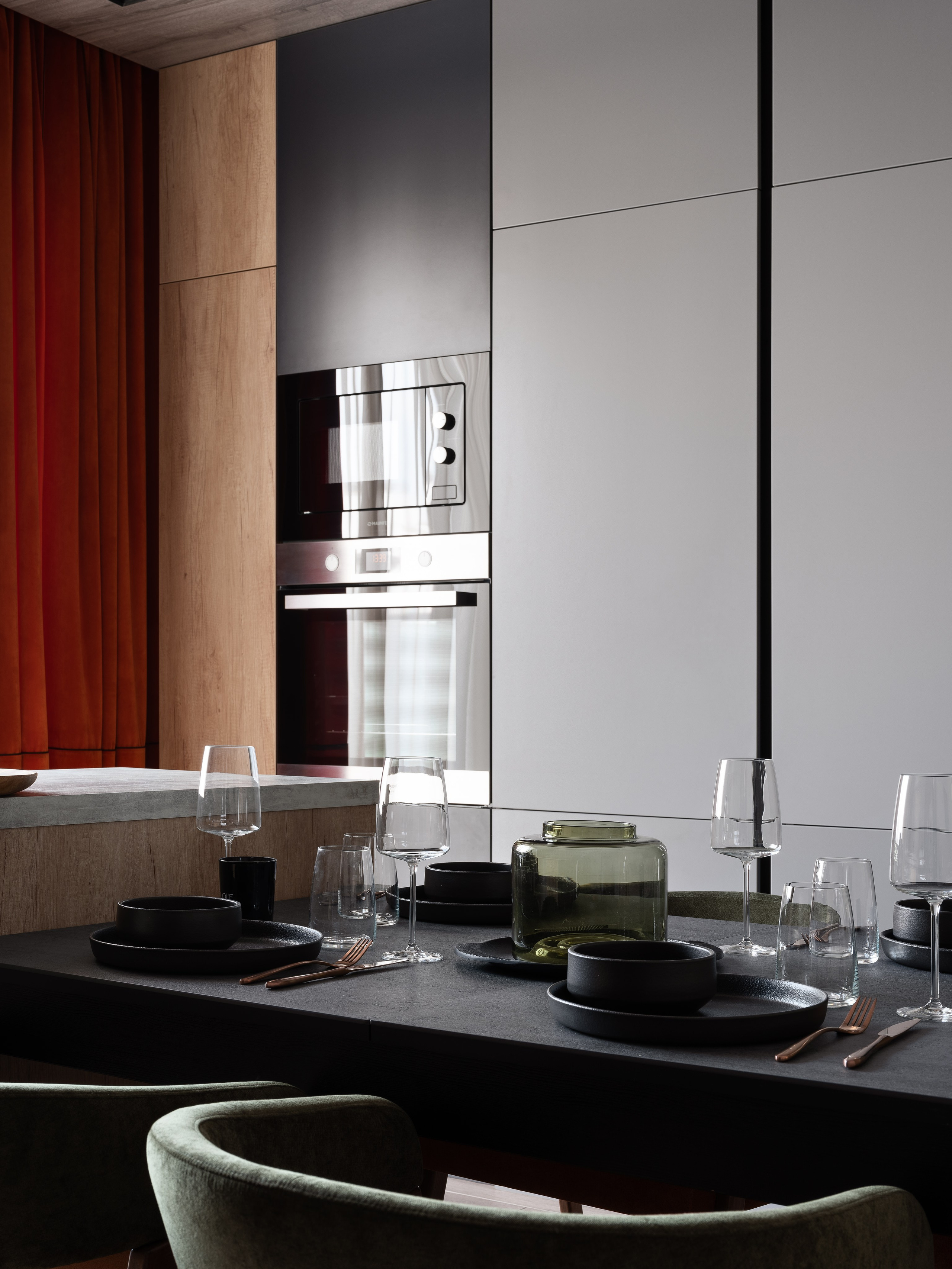 Элегантная обеденная зона в современном интерьере с черным столом, сервировкой в темных тонах и встроенной техникой; проект дизайна Екатерины Мищенко, фото Сергея Денисенко.