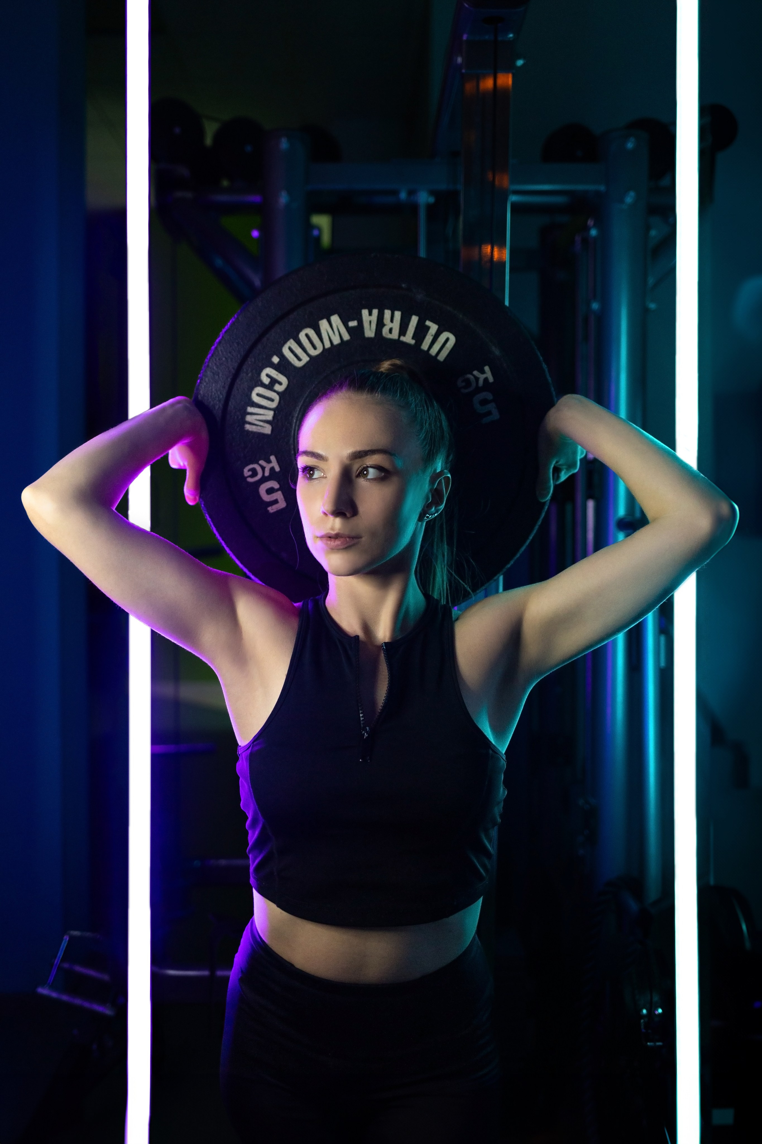 Девушка с блином от штанги за головой. Тренер по фитнесу Воронеж. Спортивный фотограф Воронеж.