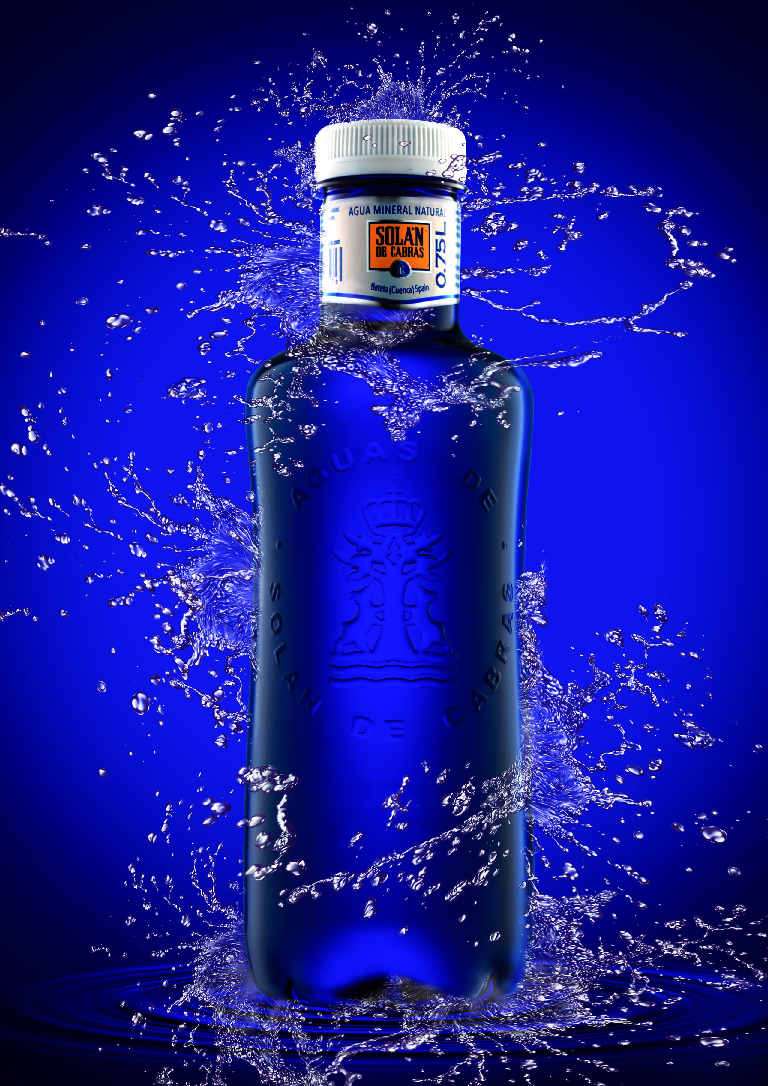 минеральная  вода solan de cabras на синем градиентном фоне с брызгами воды