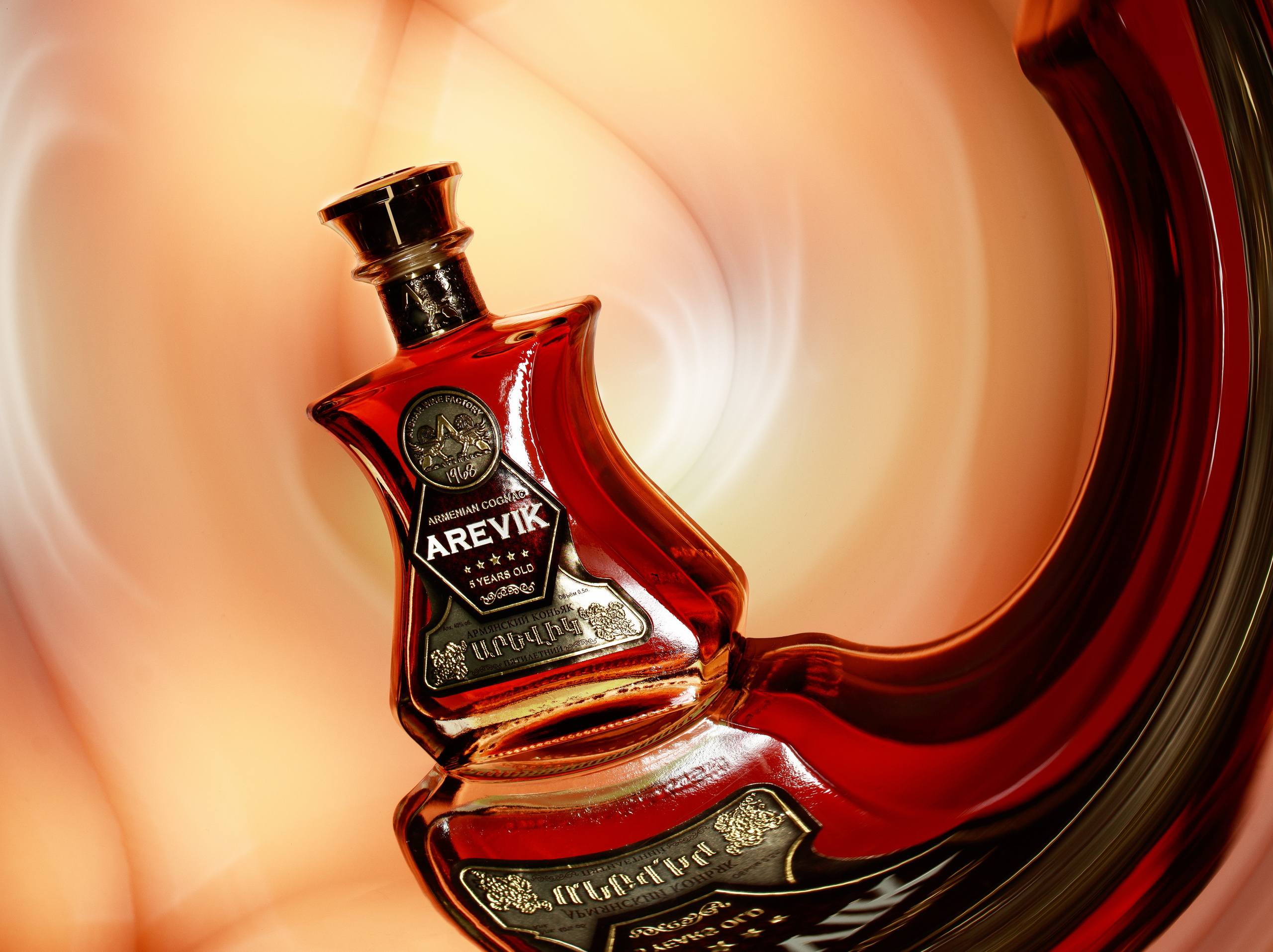 коньяк arevic на кривом зеркале на светлооранжевом фоне