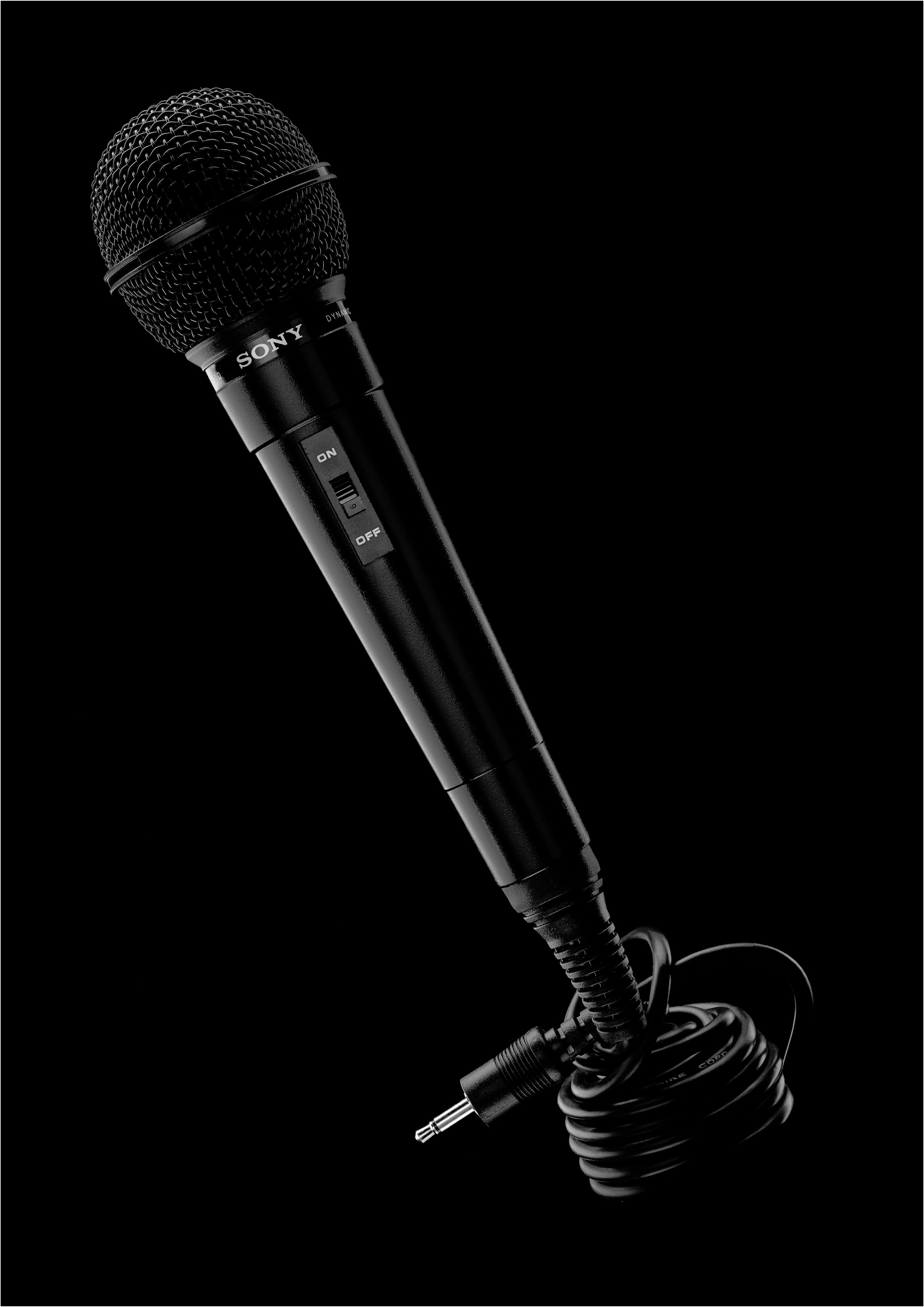микрофон  sony со смотанным в бухту шнуром на черном фоне