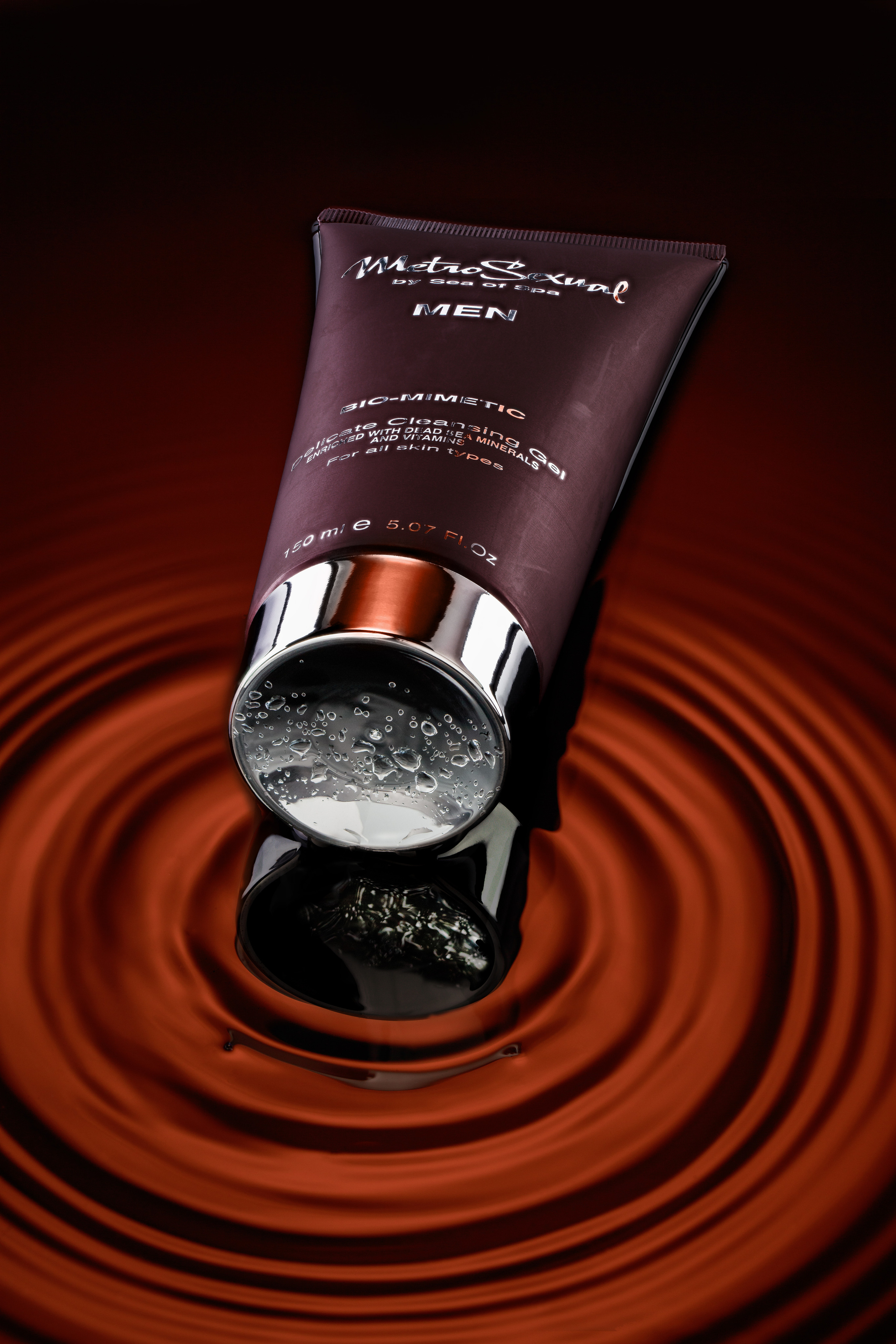 коричневый тюбик крема после бритья Metro Sexsual на фоне радиальных волн рыже-коричневого цвета