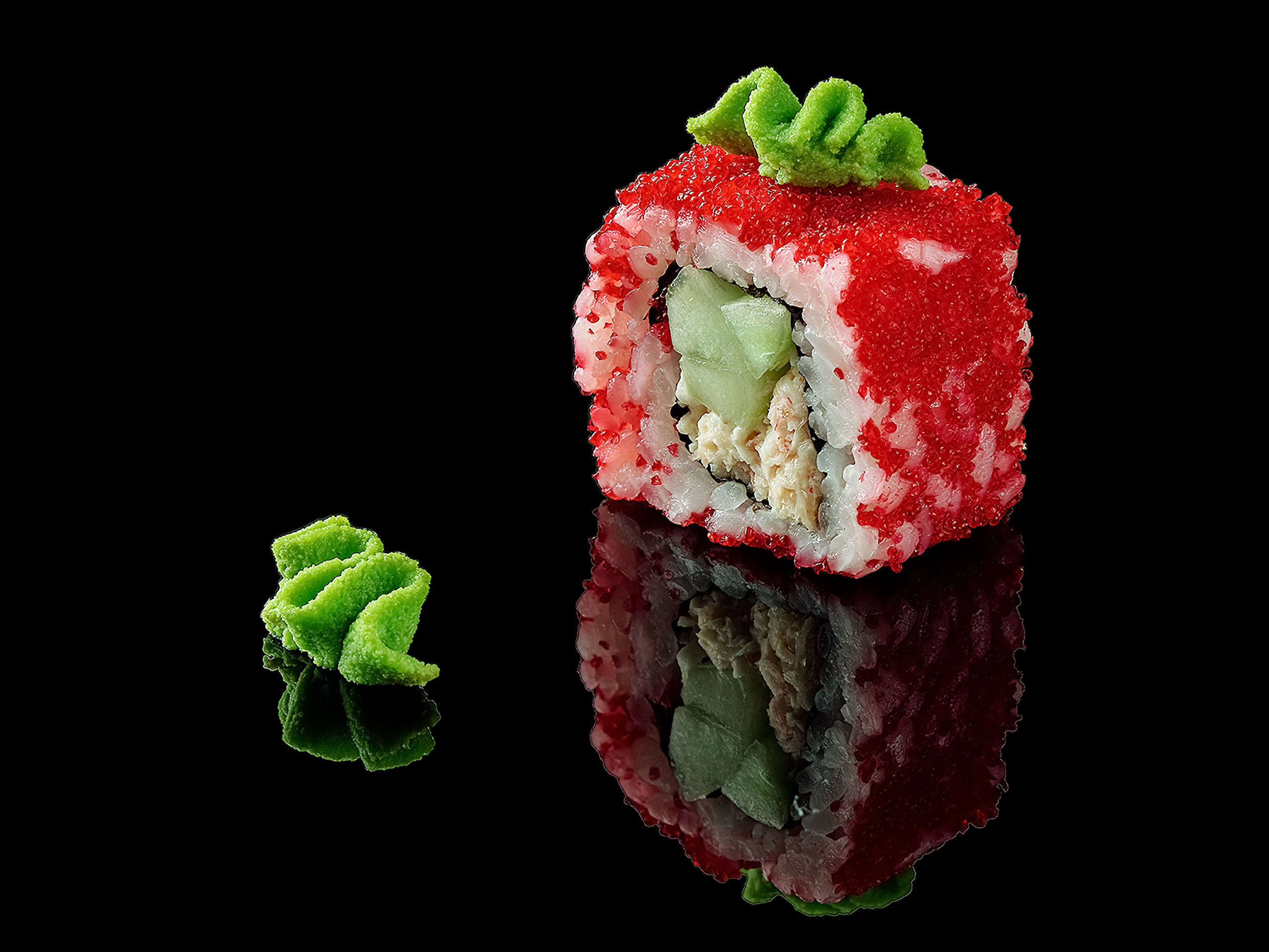 фото ролла Калифорния на черном зеркальном столе и васаби на ролле и рядом