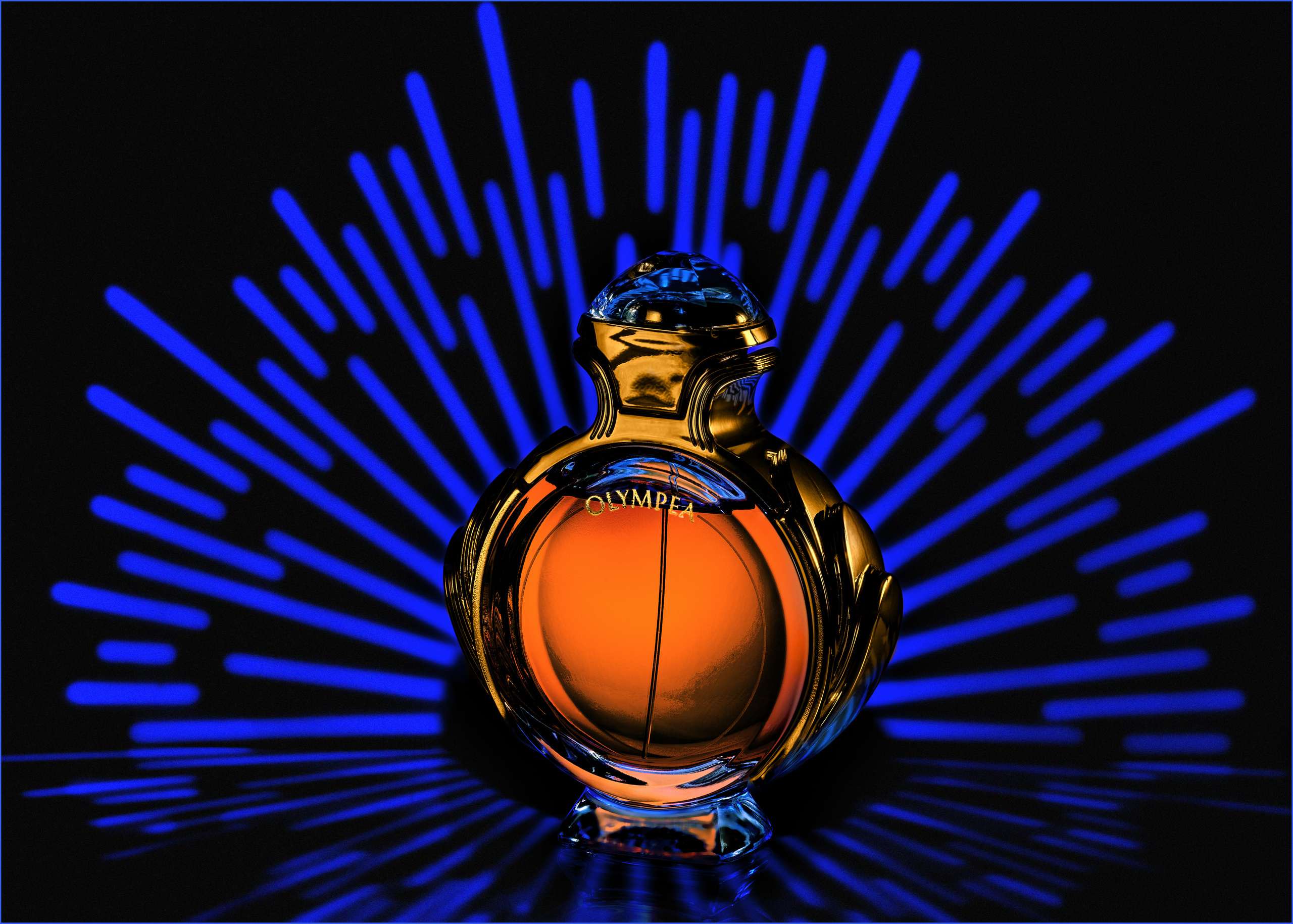 парфюм  olimpia от paco rabanne на фоне синих лучей