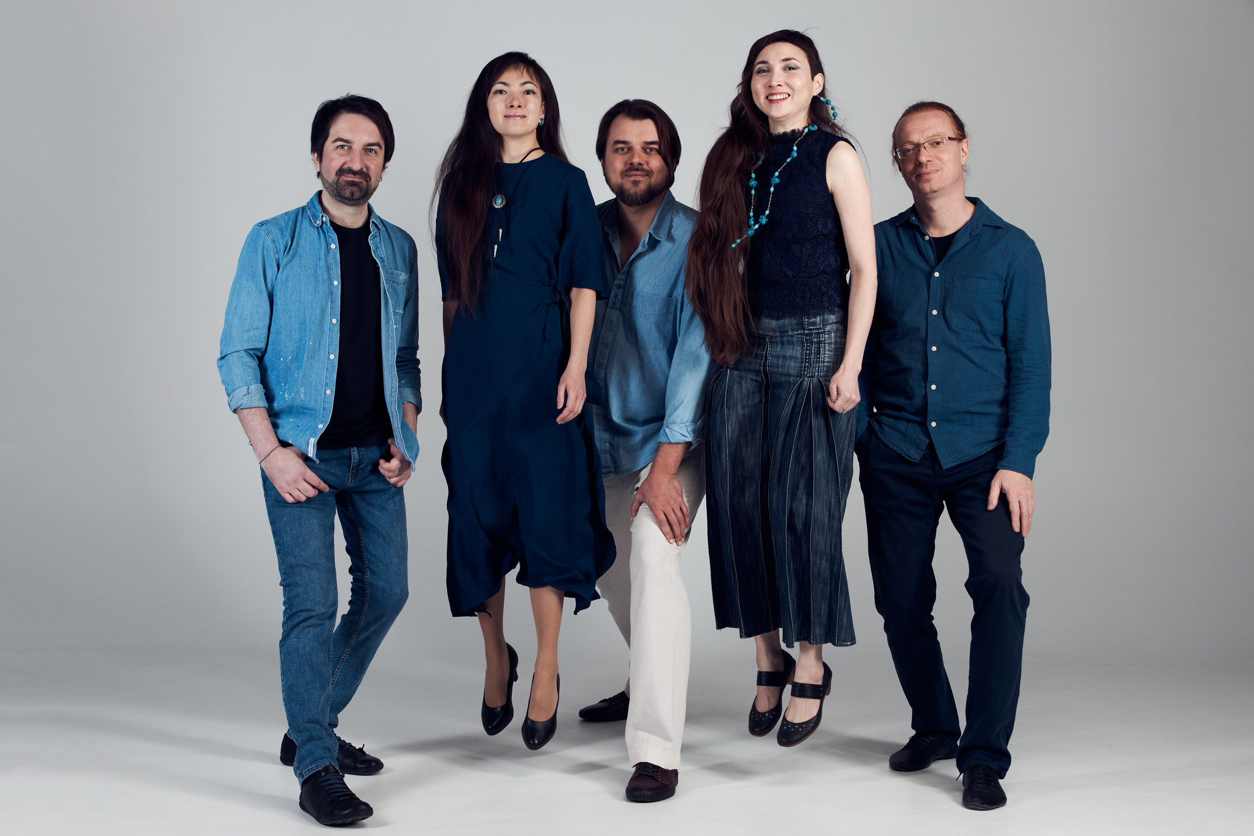 Групповой снимок пяти человек в полный рост на афишу для концерта, где  двое подпрыгивают, а трое стоят