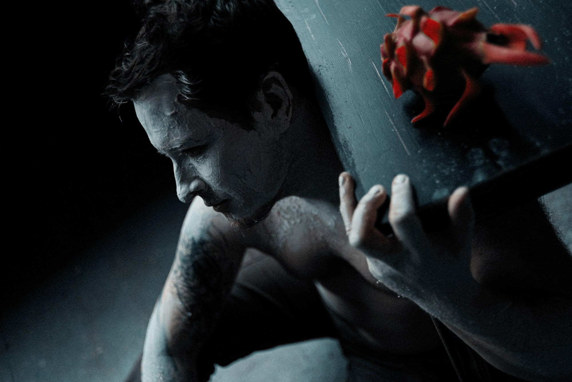 Силуэтный мужской портрет на черном фоне, графичный свет, подчеркивающий контуры лица и фактуру грима