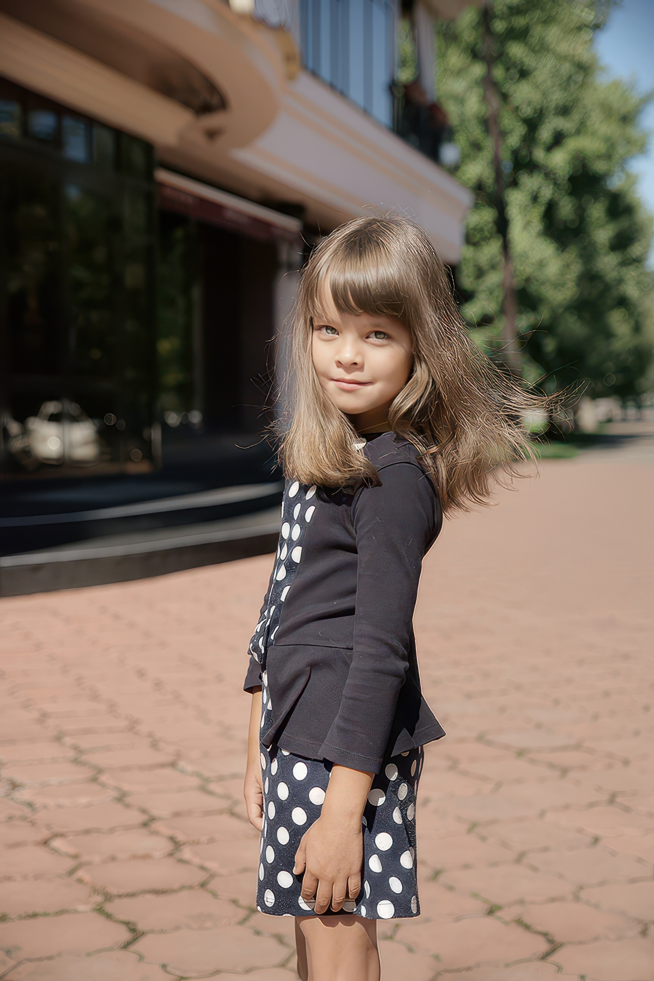 Детская фотосессия летом - девочка стоя у ресторана