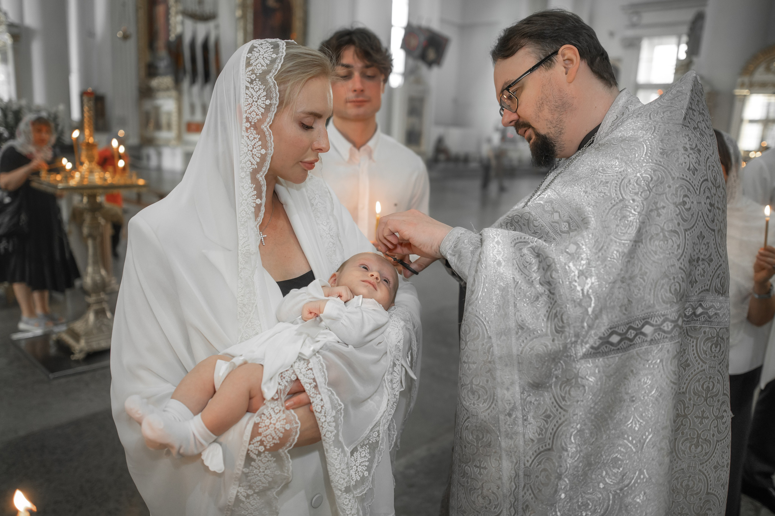 священник постригает малышку на крещении в Троице Измайловском соборе