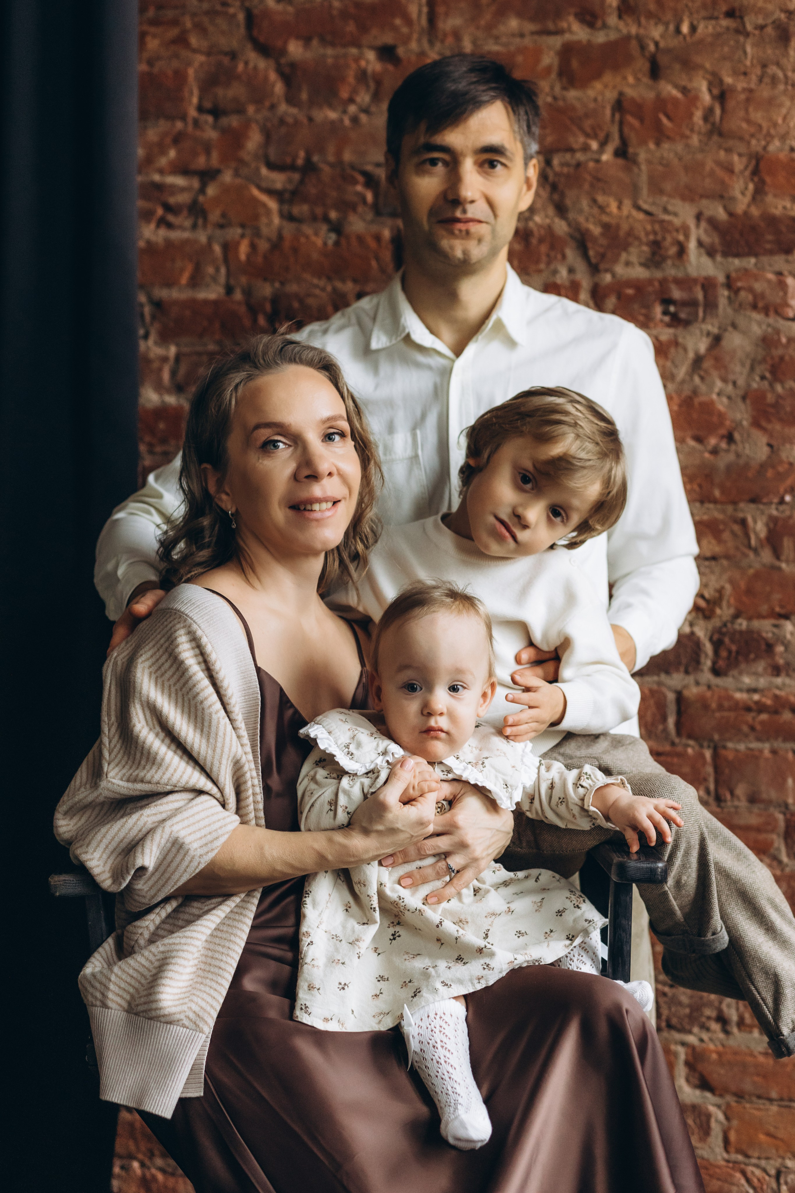 дружная  семья  в студии на фоне кирпичной стены