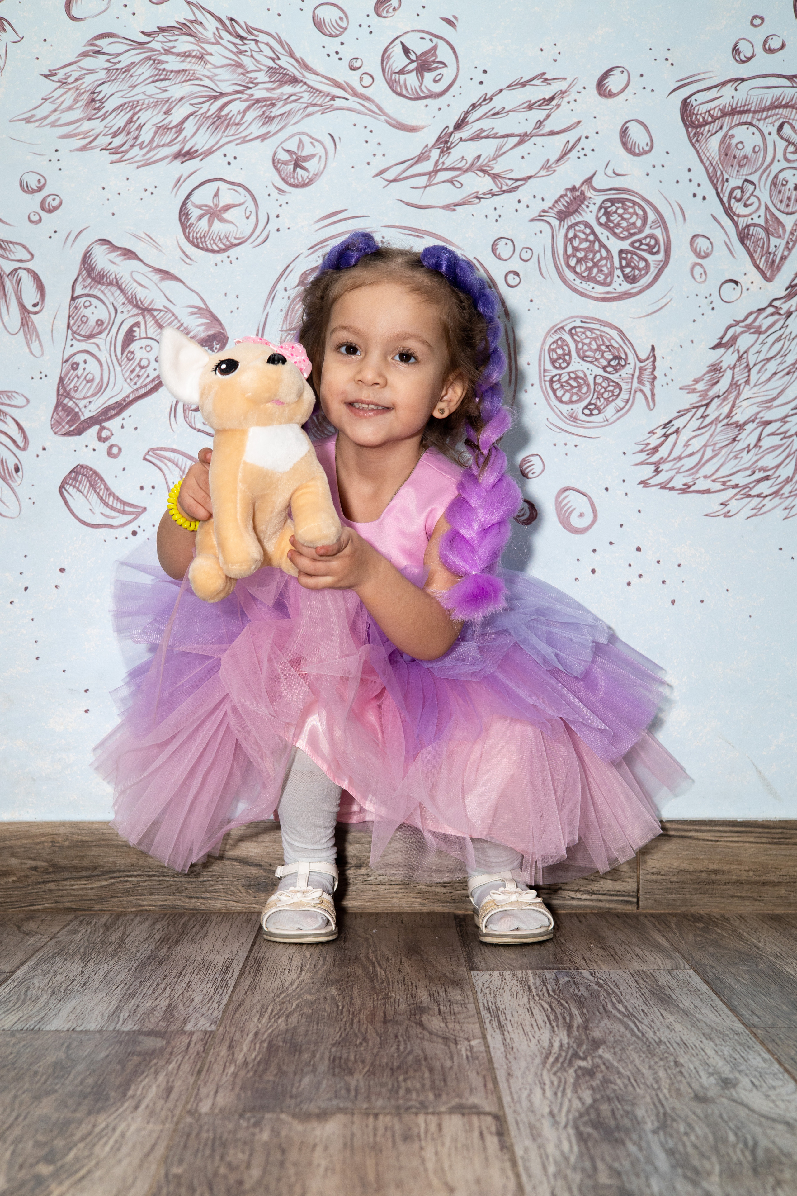 Маленькая девочка в розовом платье сидит на корточках, в руках игрушка. Детский день рождения  Астрахань.