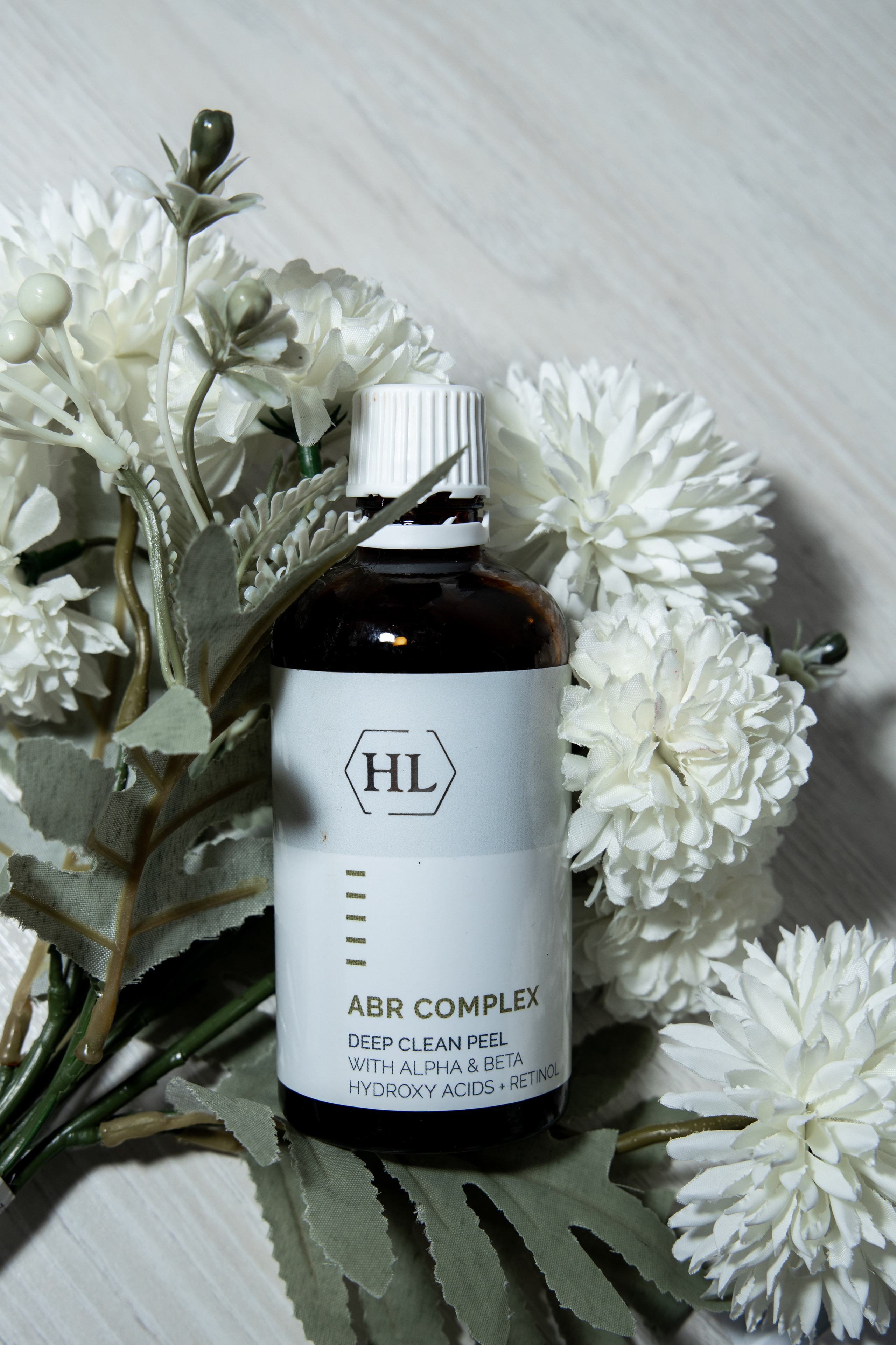 Пузырек с косметикой среди цветов. Предметная съёмка. Съёмка в Астрахани.