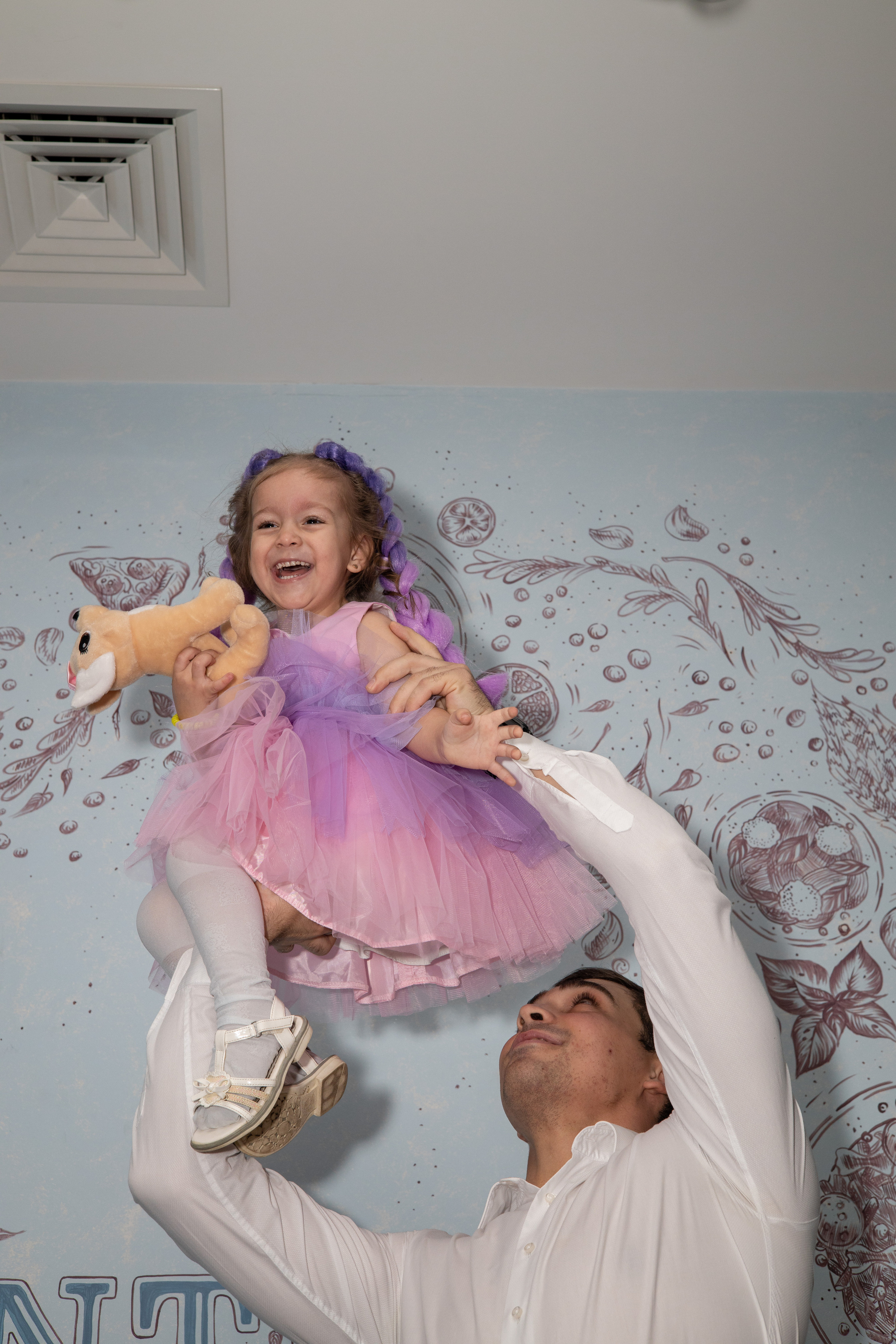 Папа на высоко поднятых руках держит дочку. Детский день рождения  Астрахань.