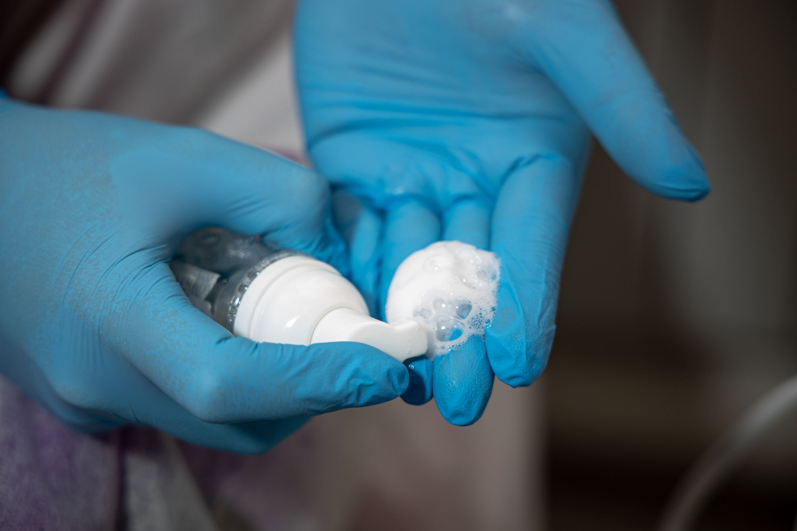 Руки в синих медицинских перчатках с косметической пенкой. Контент для мастеров. Съёмка в Астрахани.