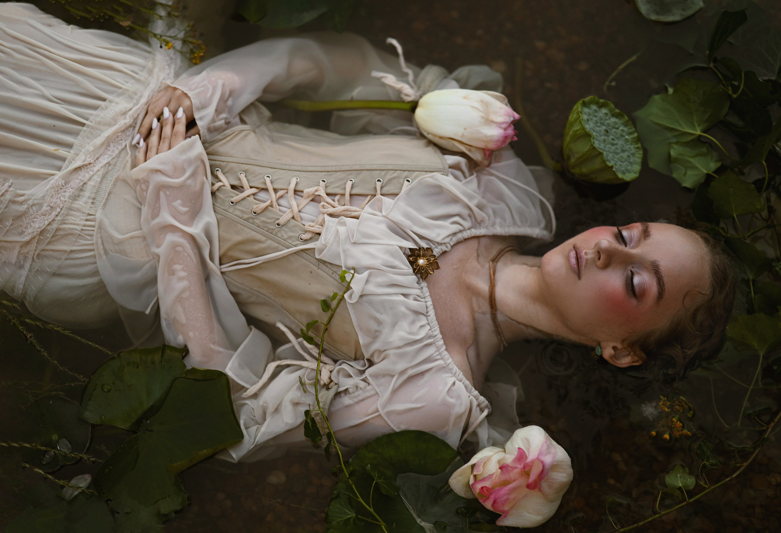 Стилизованная фотосессия девушки в воде в Абхазии, девушка лежит в воде среди лотосов