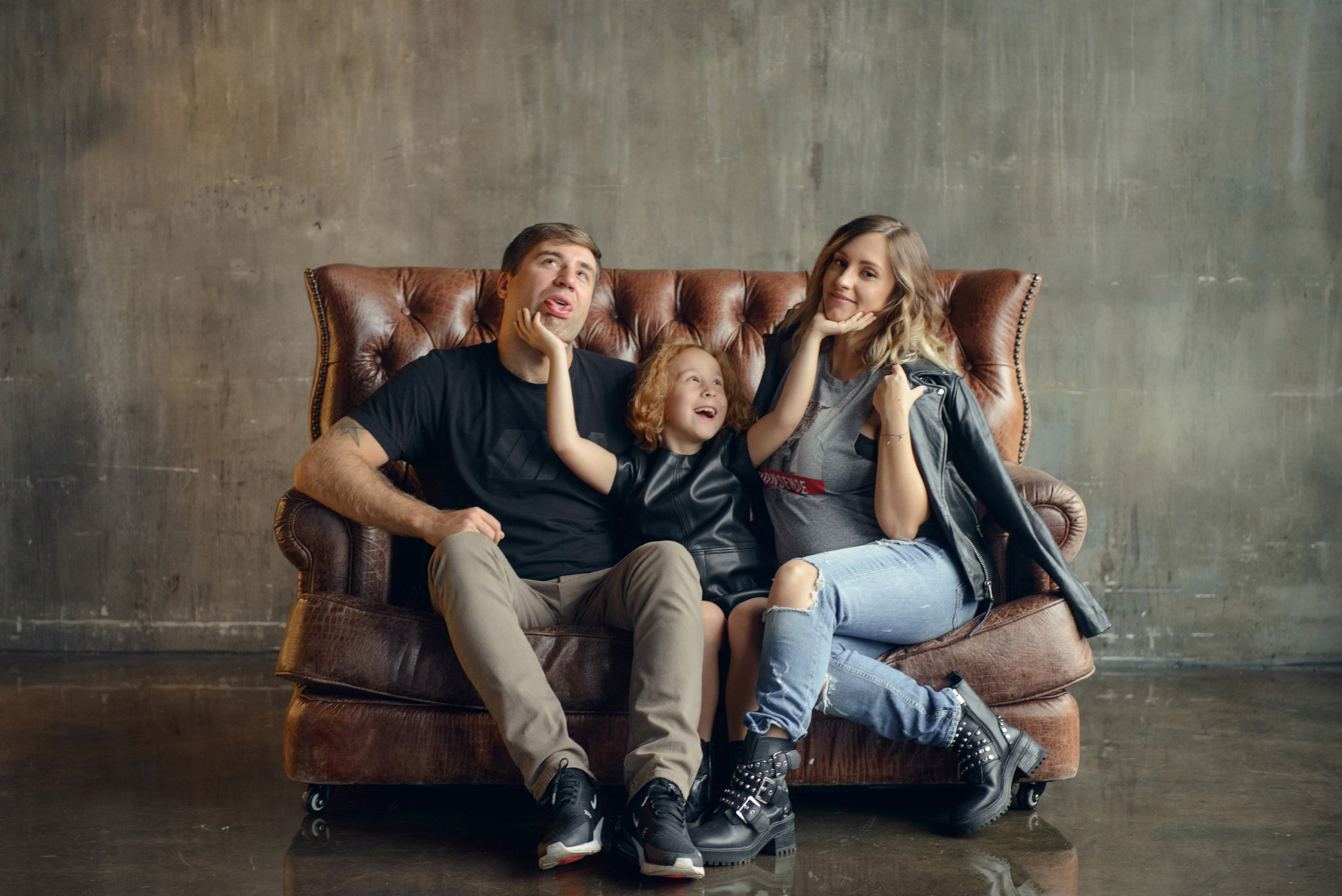 Family photo shoot with a pregnant woman in a loft studio, rock and roll style