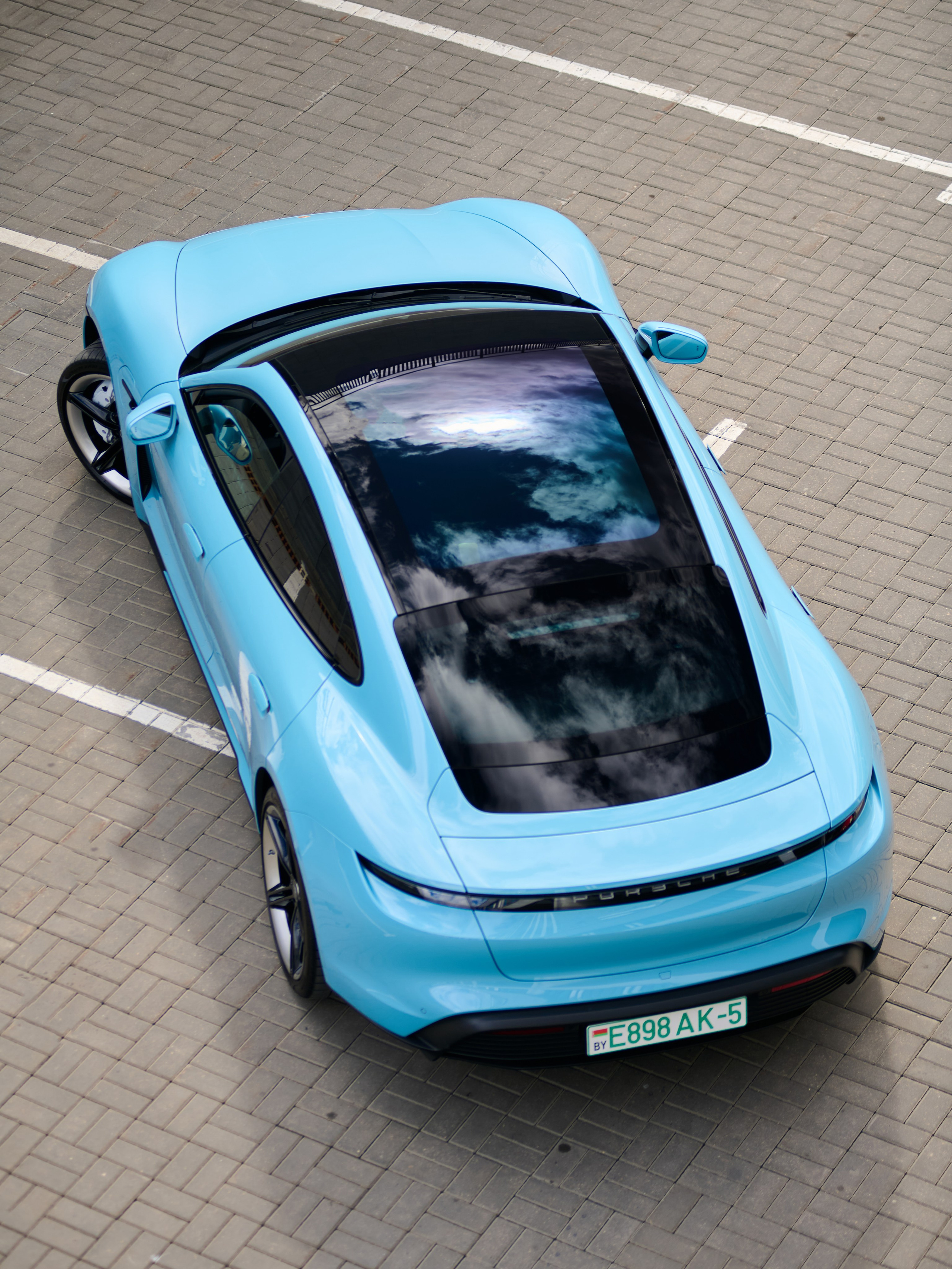 Голубой Porsche Taycan 4S сверху, вид на панорамную крышу