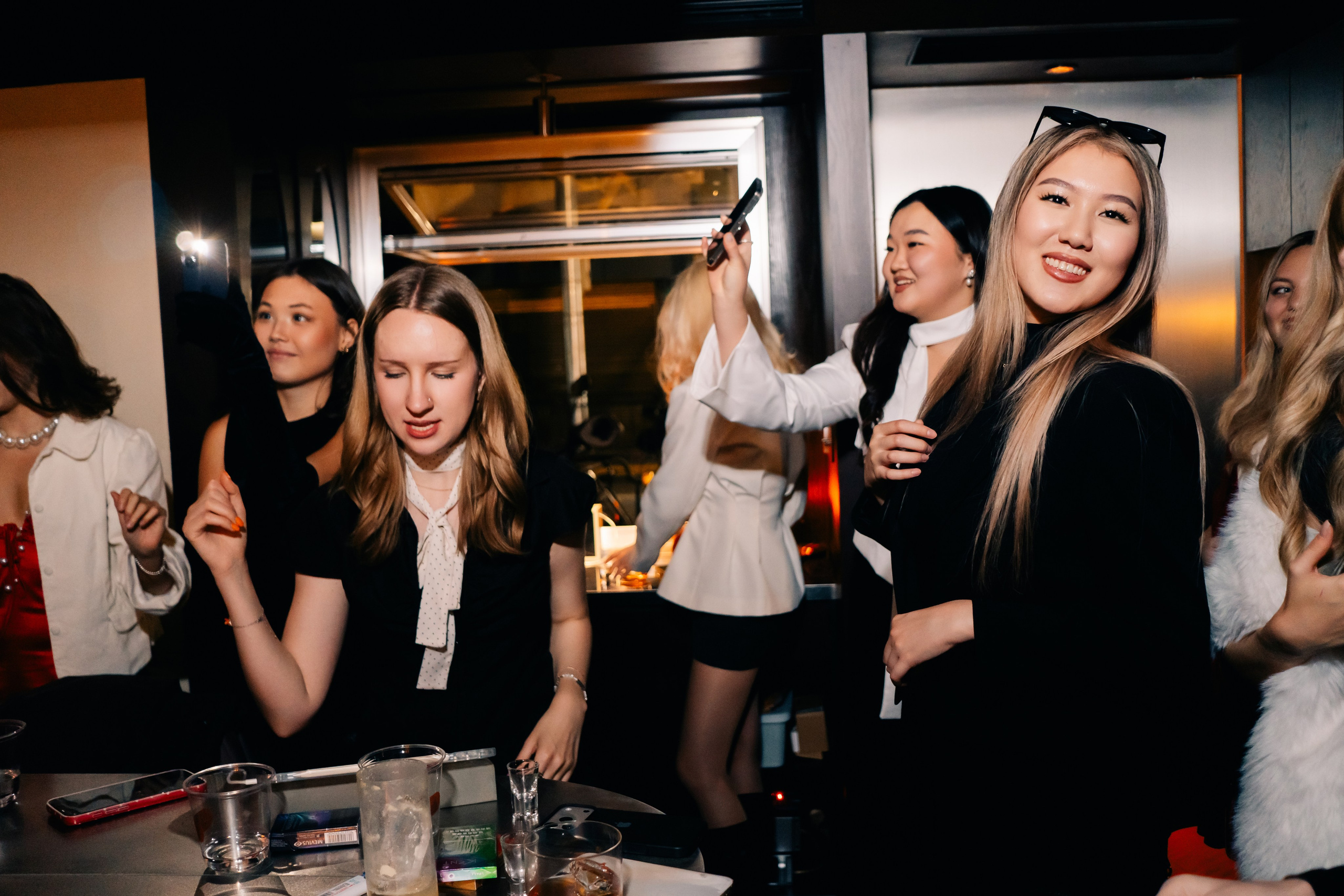 Guests dancing at a bar party in Shanghai, reportage photography, bright light and movement.