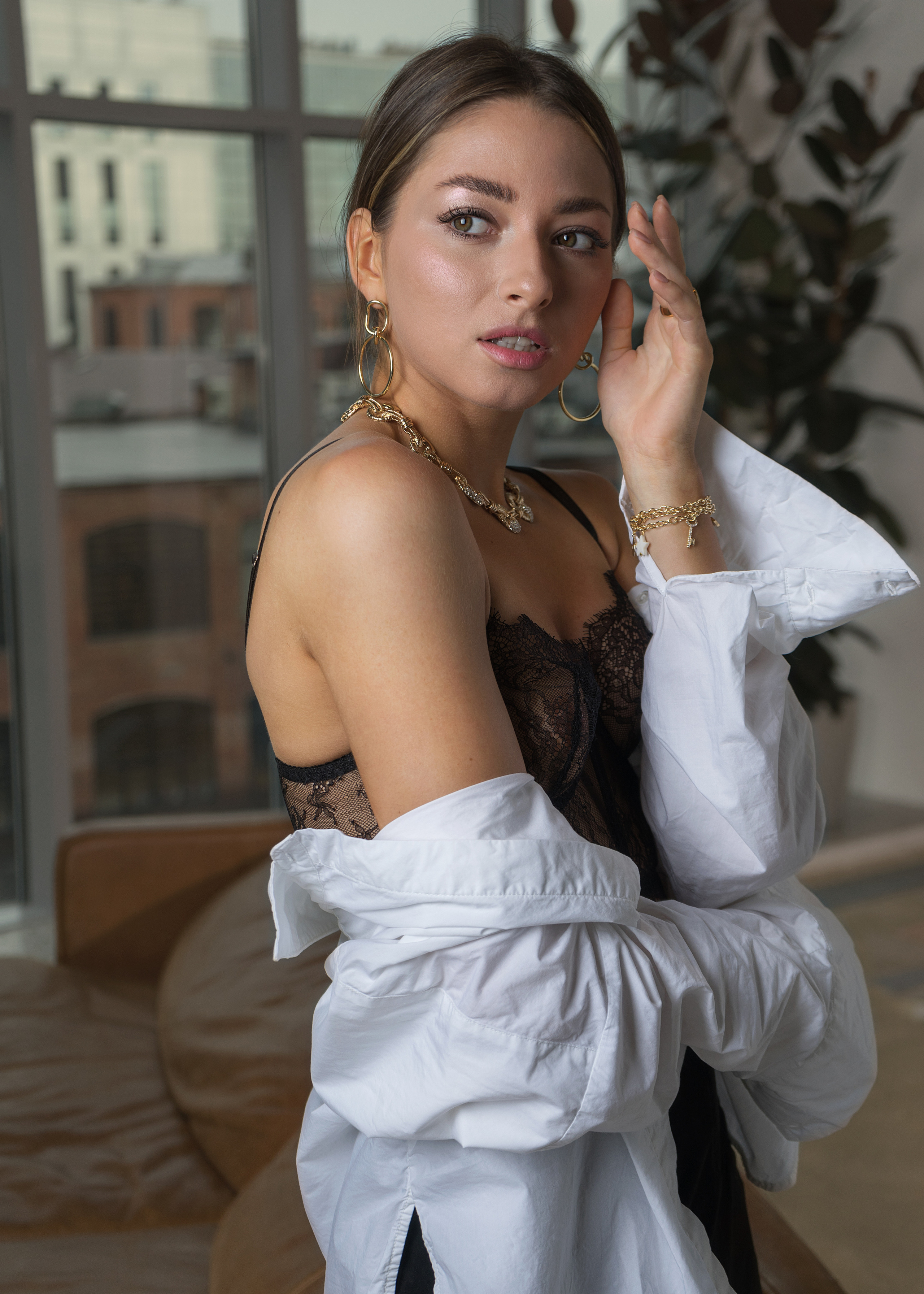 Красивая молодая девушка с тёмными волосами в белой рубашке с оголенными плечами