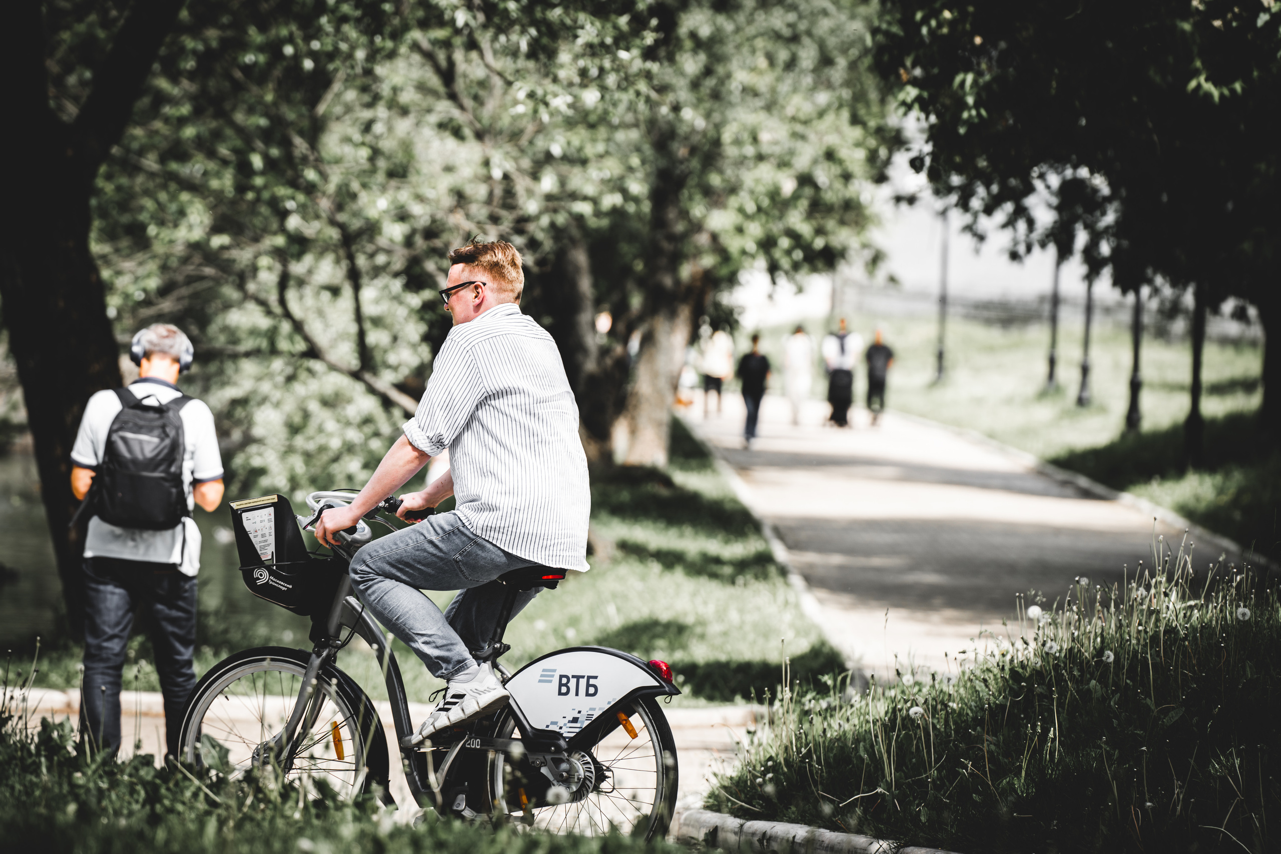 Велосипедист на прокатном велосипеде в парке у Новодевичьего монастыря