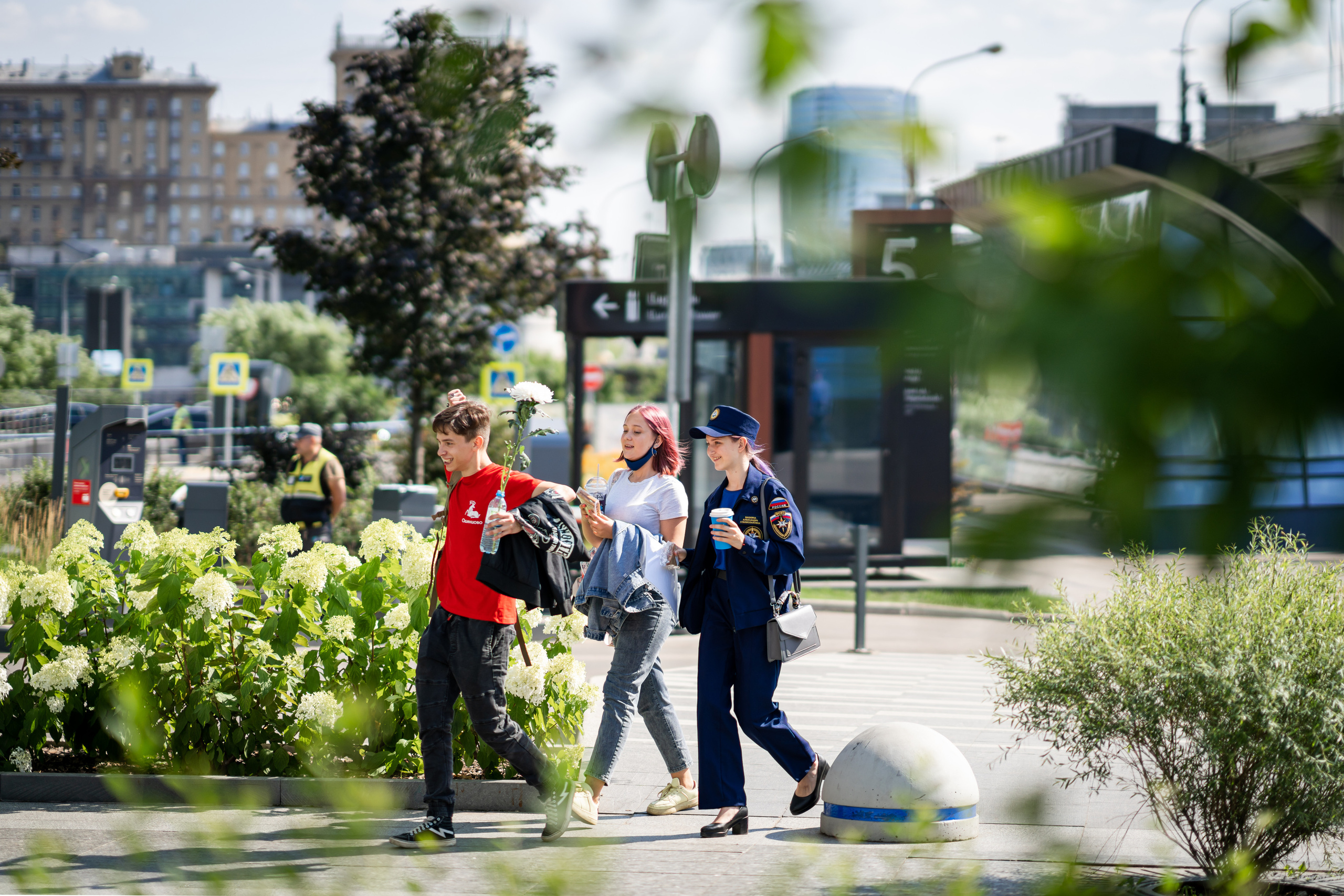 Трое молодых людей с цветами в Москва-Сити