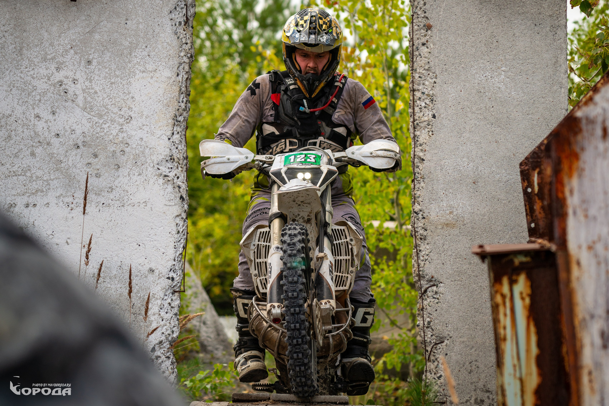 Эндуро-спортсмен в защитной амуниции проходит сложный участок трассы.