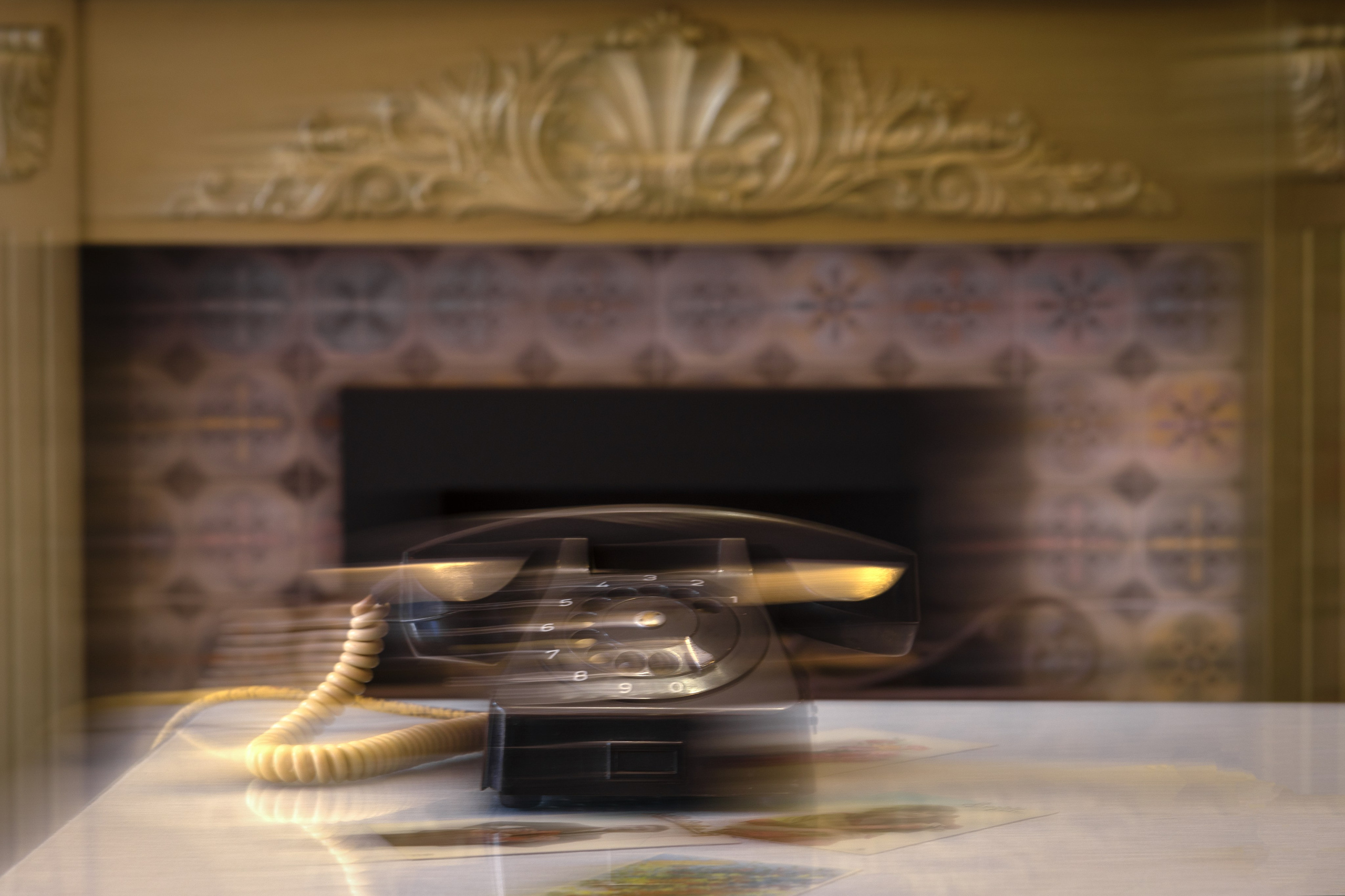 старинный черный телефон стоит на столе и звонит