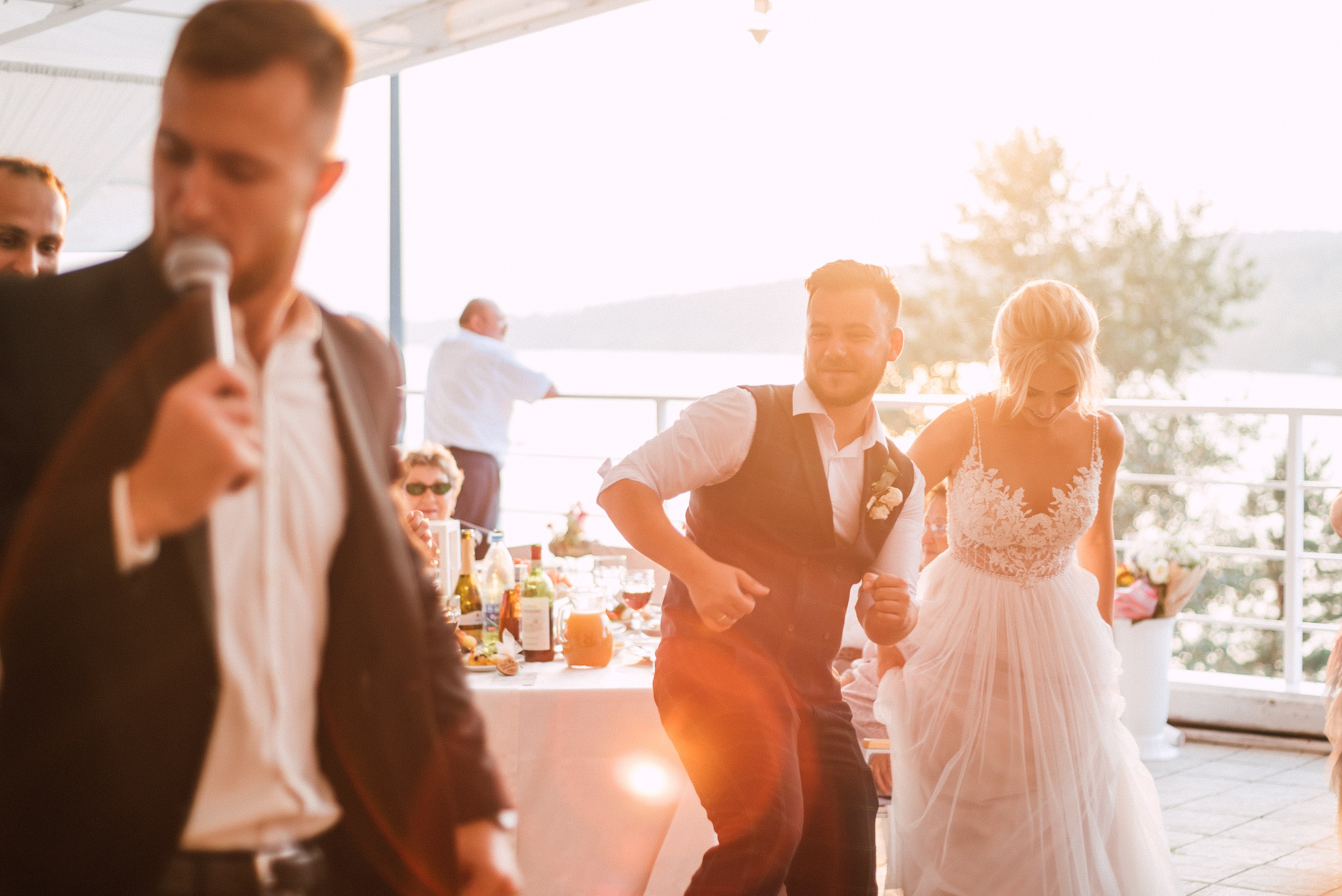 Молодожены и гости танцуют на закате