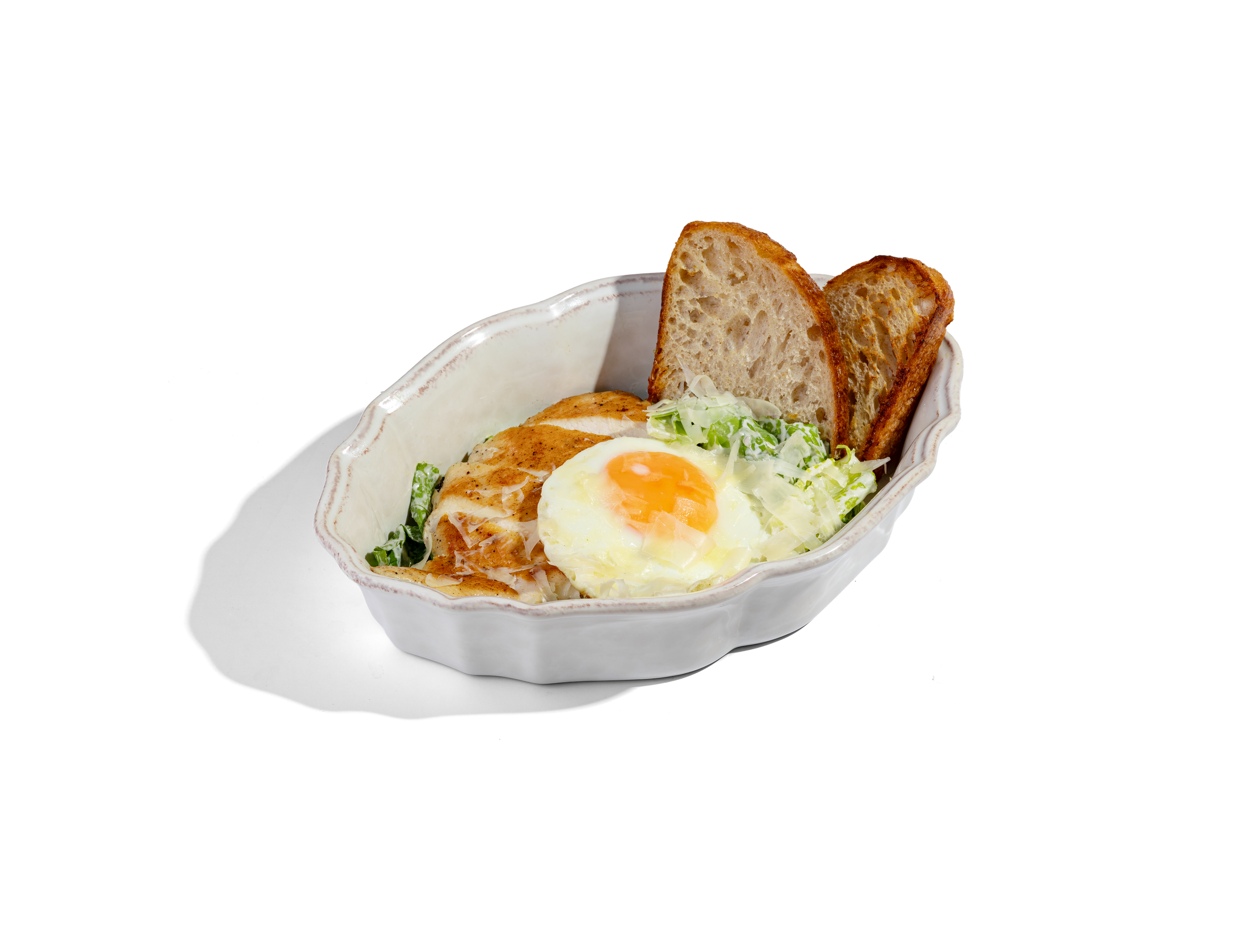 САЛАТ С ЦЫПЛЕНКОМ И СОУСОМ ТОНАТО — 950₽. Листья салата романо, цыпленок - гриль, яйцо - глазунья, заправлен соусом тонато и украшается тертым сыром грюйер. Салат подается с гренками хлеба Тартин. 