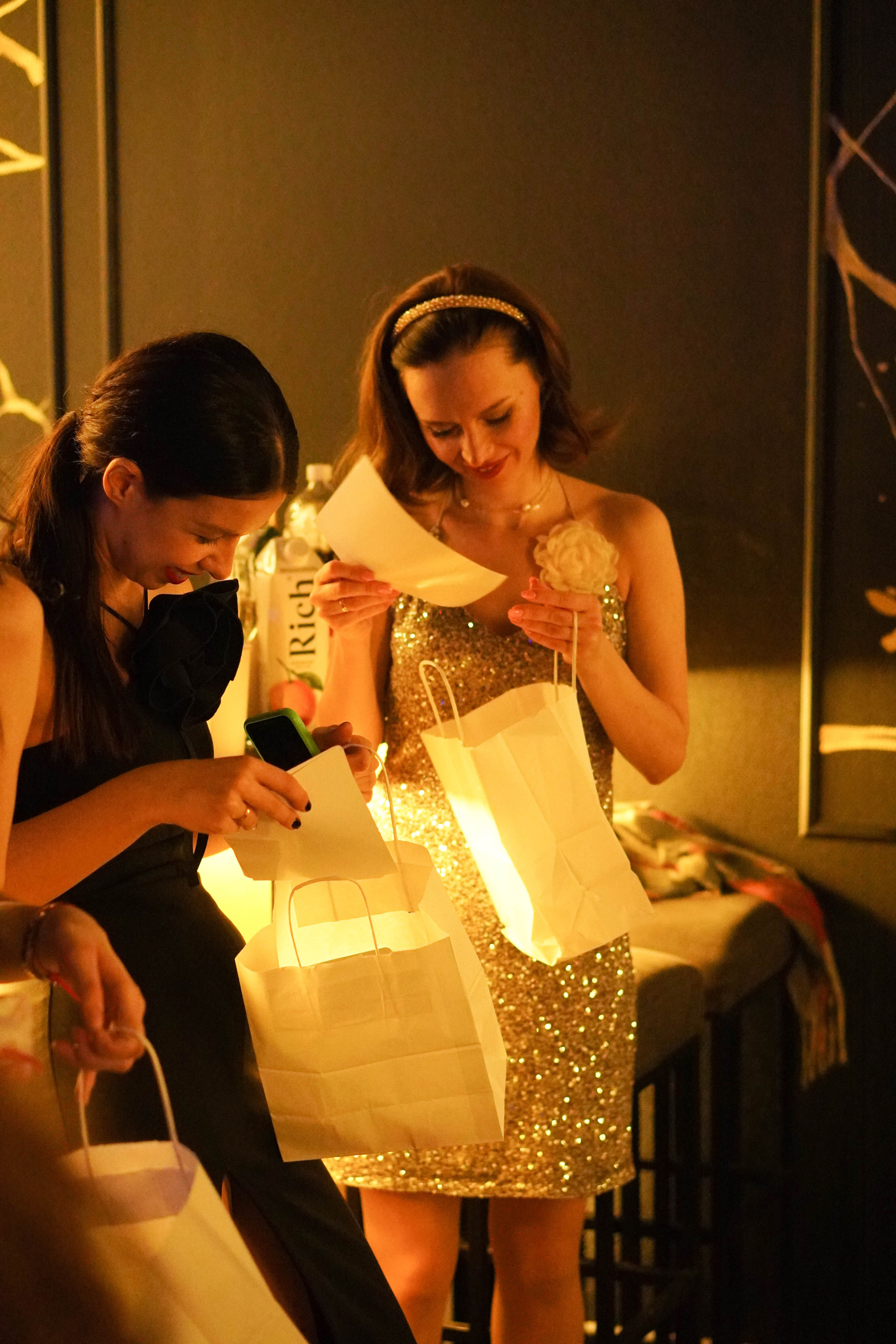 Девушки на корпоративе поучают подарки 