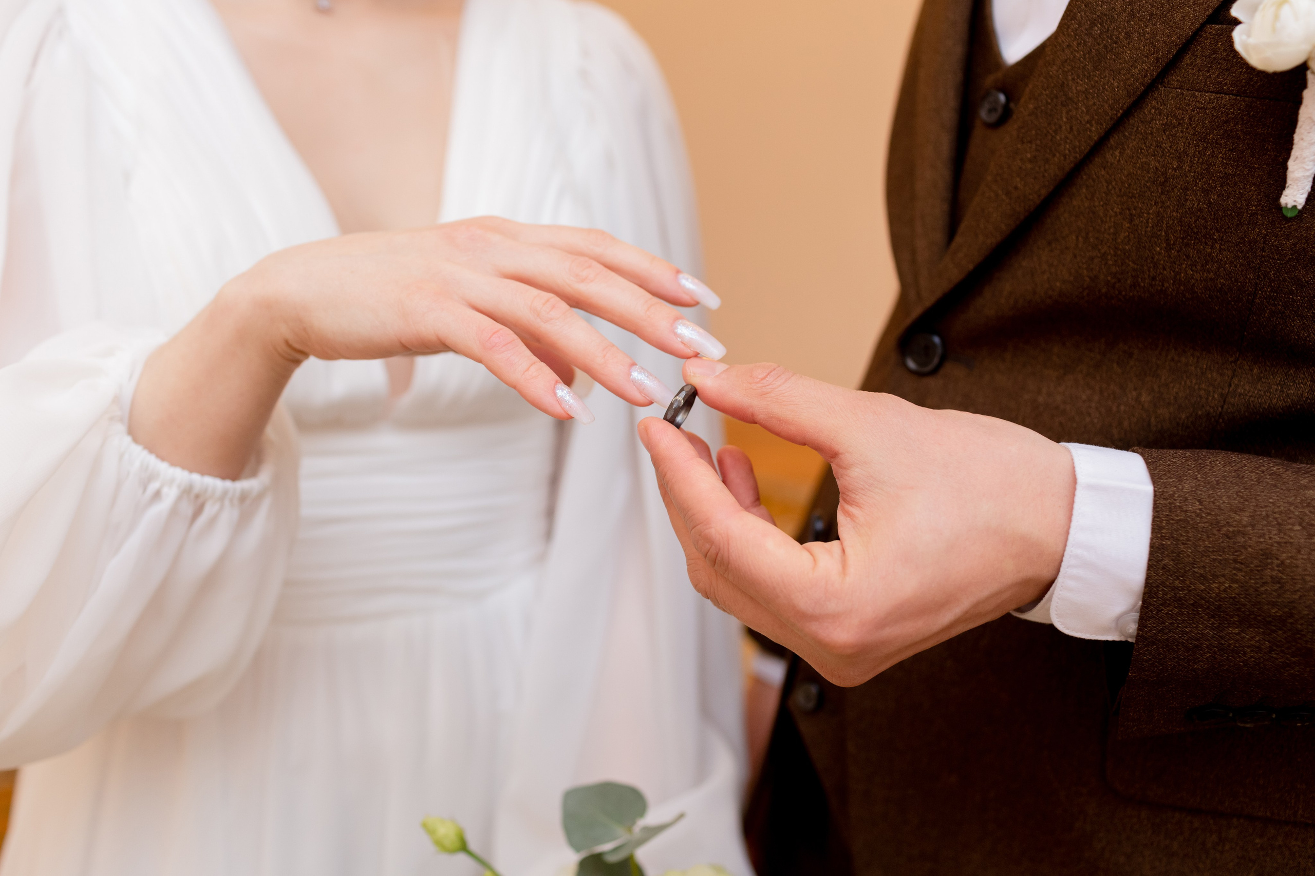 Жених надевает обручальное кольцо невесте.