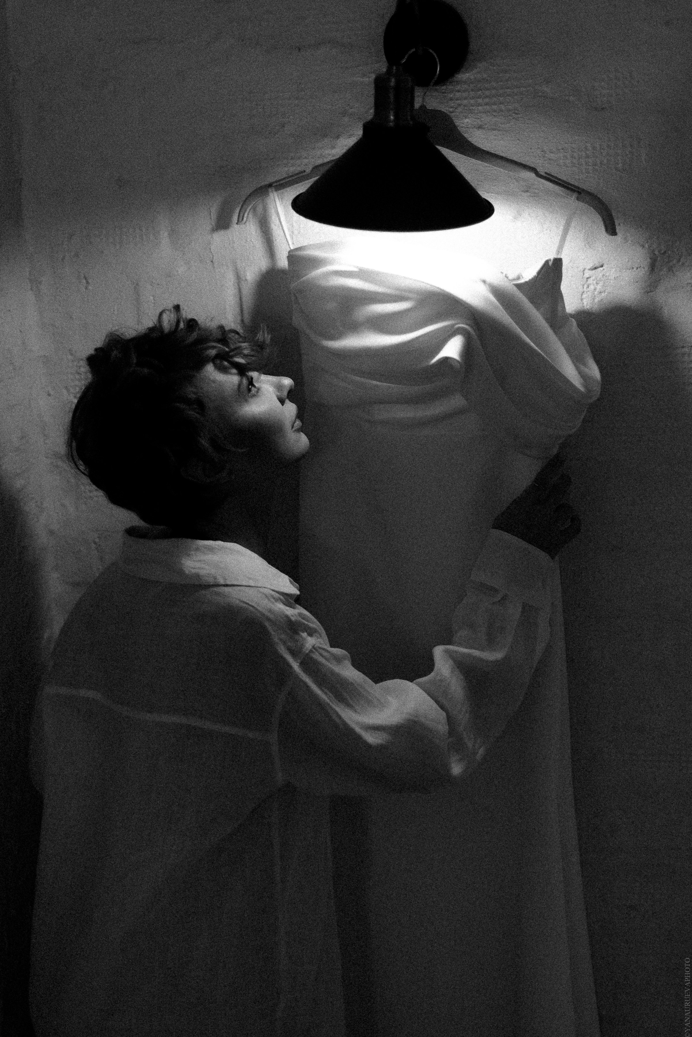 Невеста нежно смотрит на своё свадебное платье