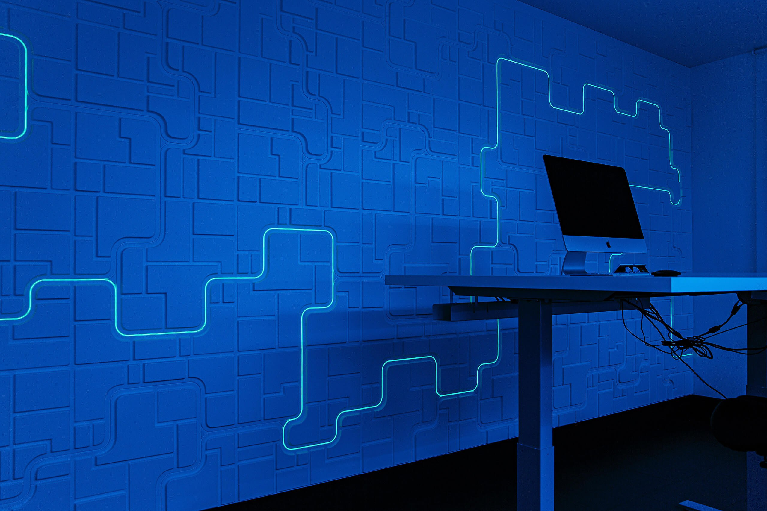 Фотосъемка интерьера для IT-компании: рабочее место с рельефной 3D-стеной и неоновой подсветкой в Пензе.