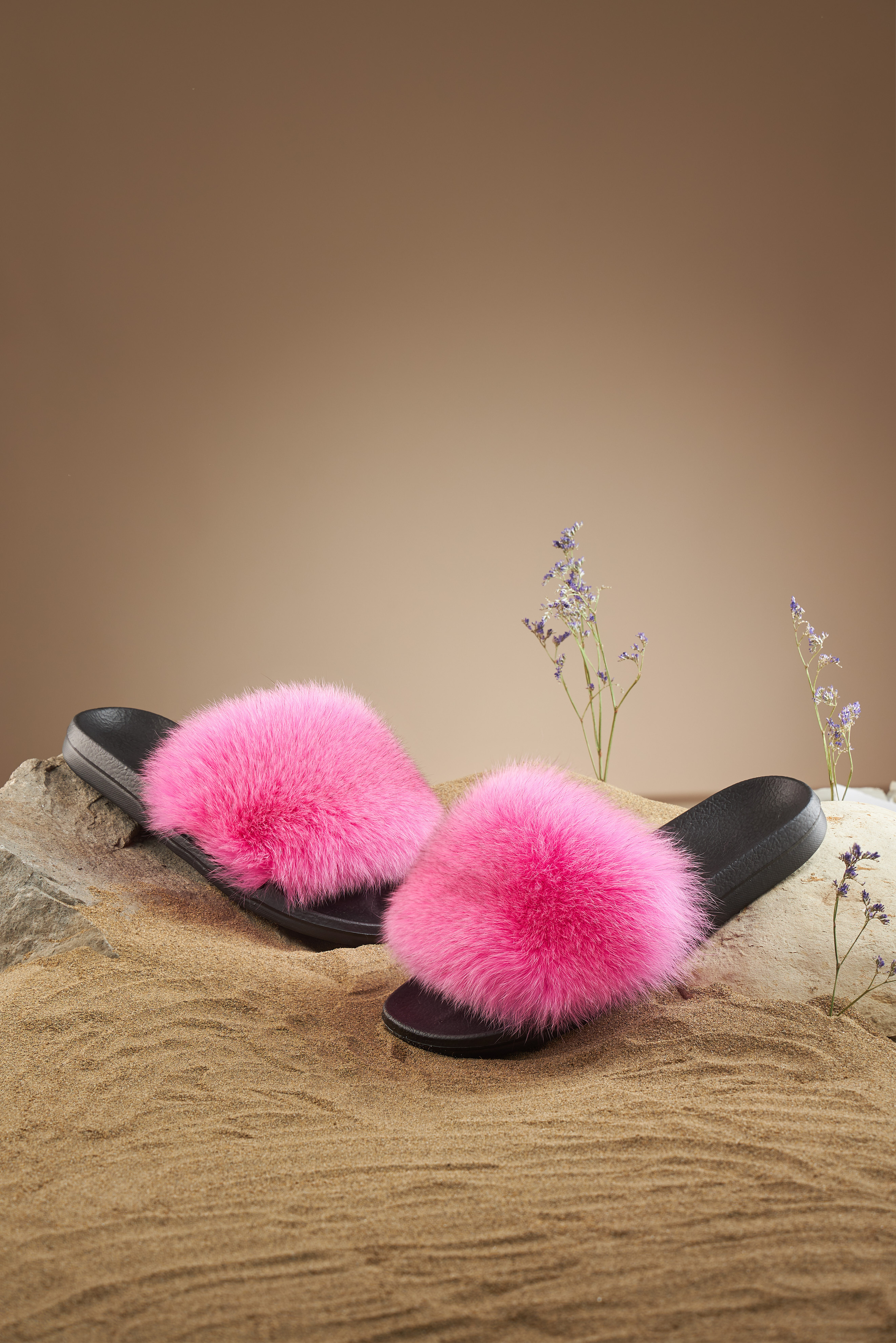 Тапочки с розовым мехом на коричневом фоне, на песке
