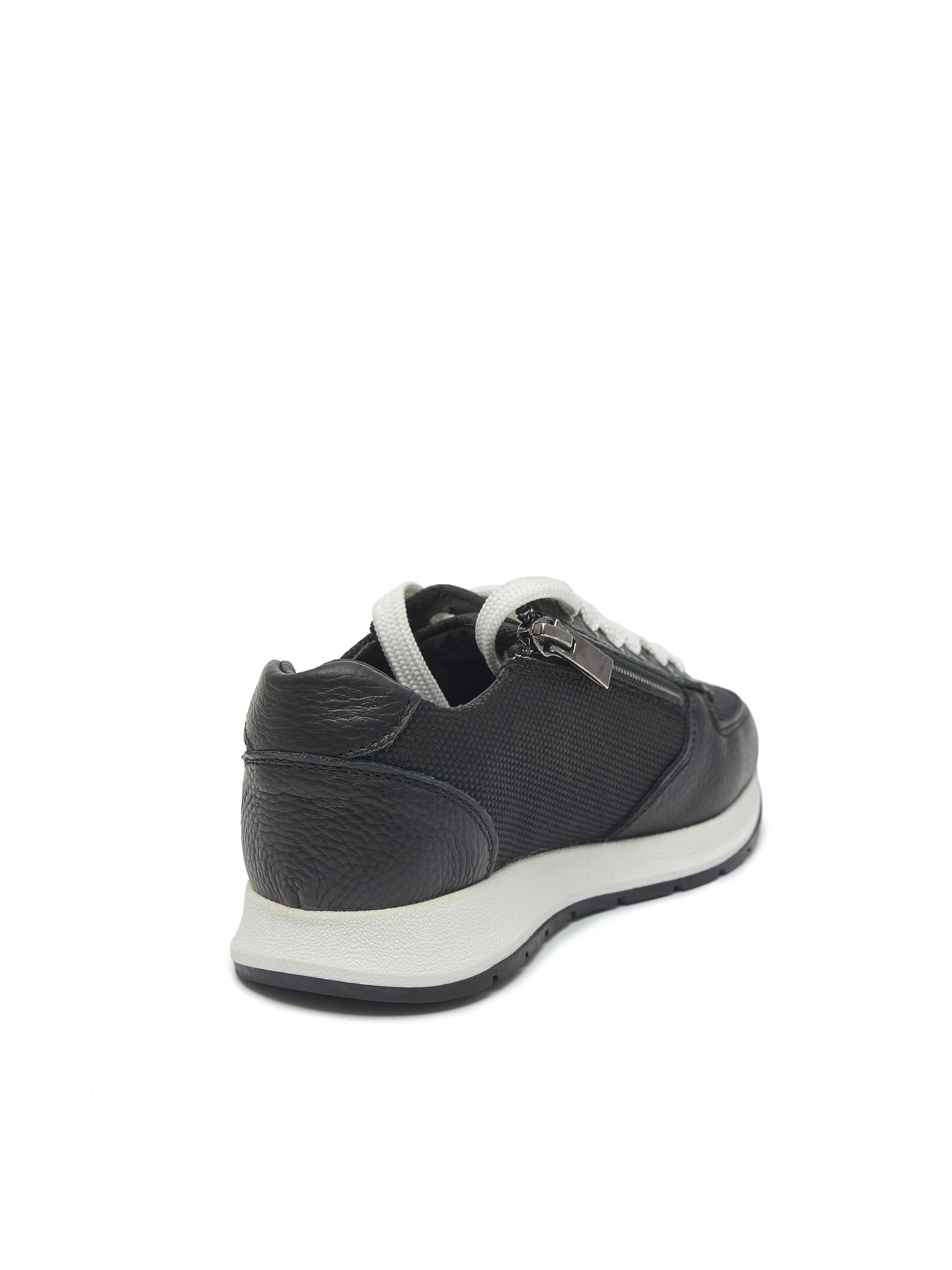 Левый кроссовок черного цвета с белыми шнурками на белом фоне вид сзади