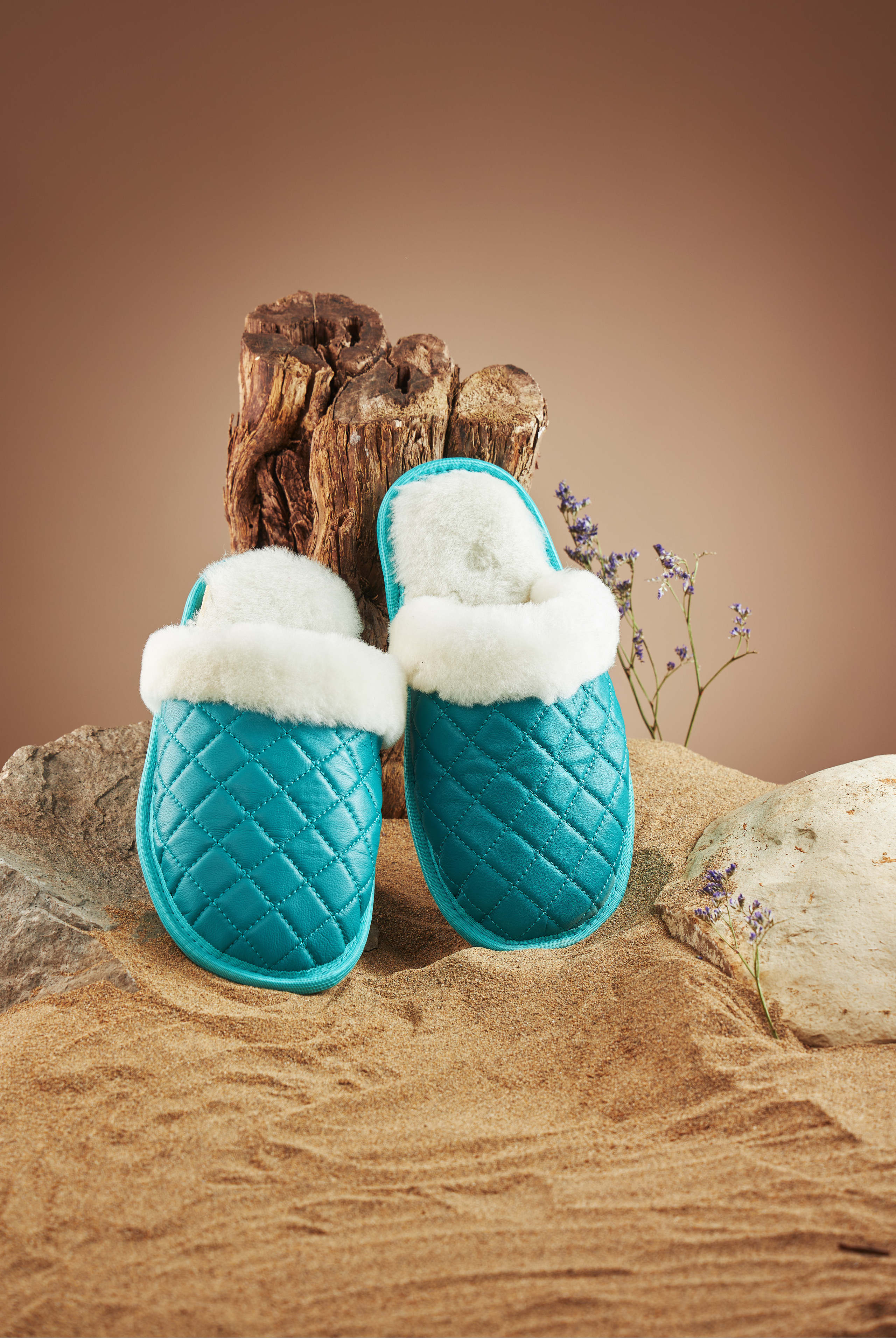 Зеленые тапочки на коричневом фоне, на песке, коряга