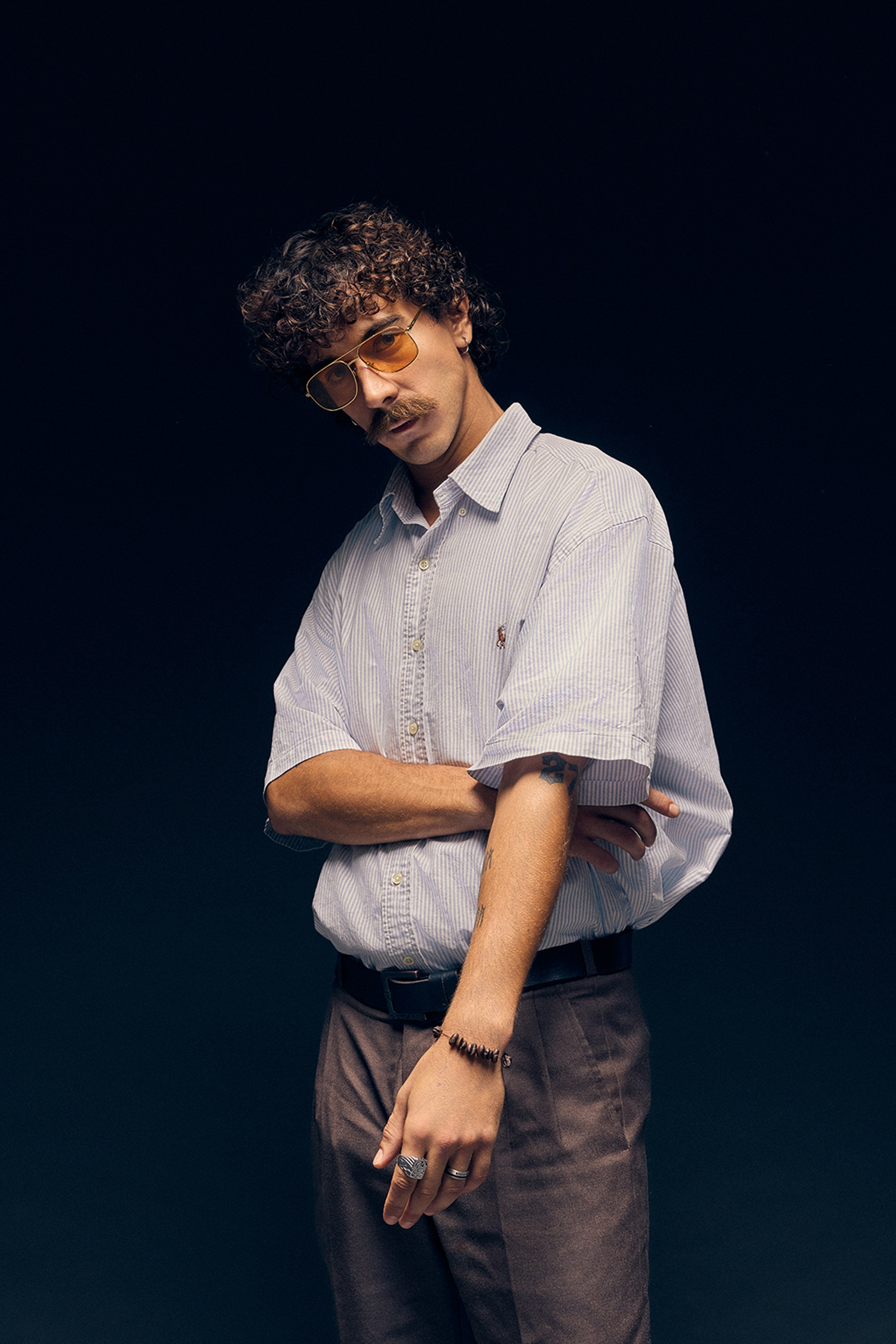 Retro styled man sitting with flour and tequila bottle in artistic photo shoot