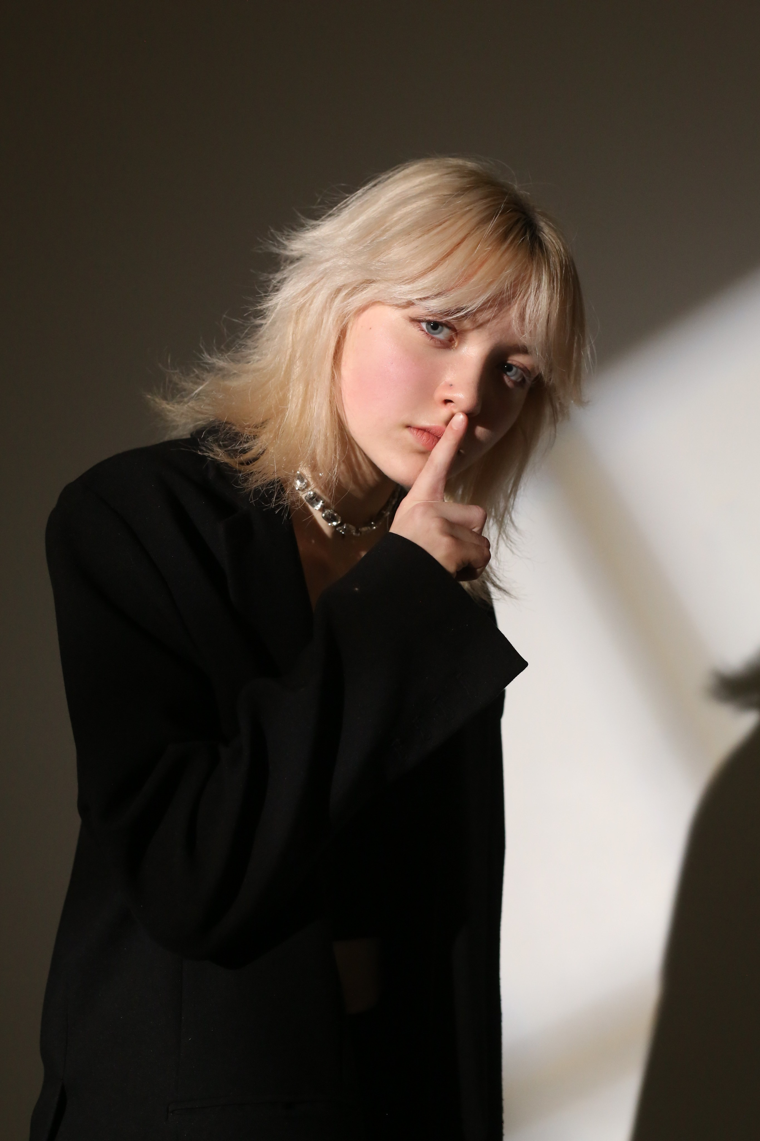 Студийная фотосессия «Геометрия»: девушка в черном костюме позирует в лучах света