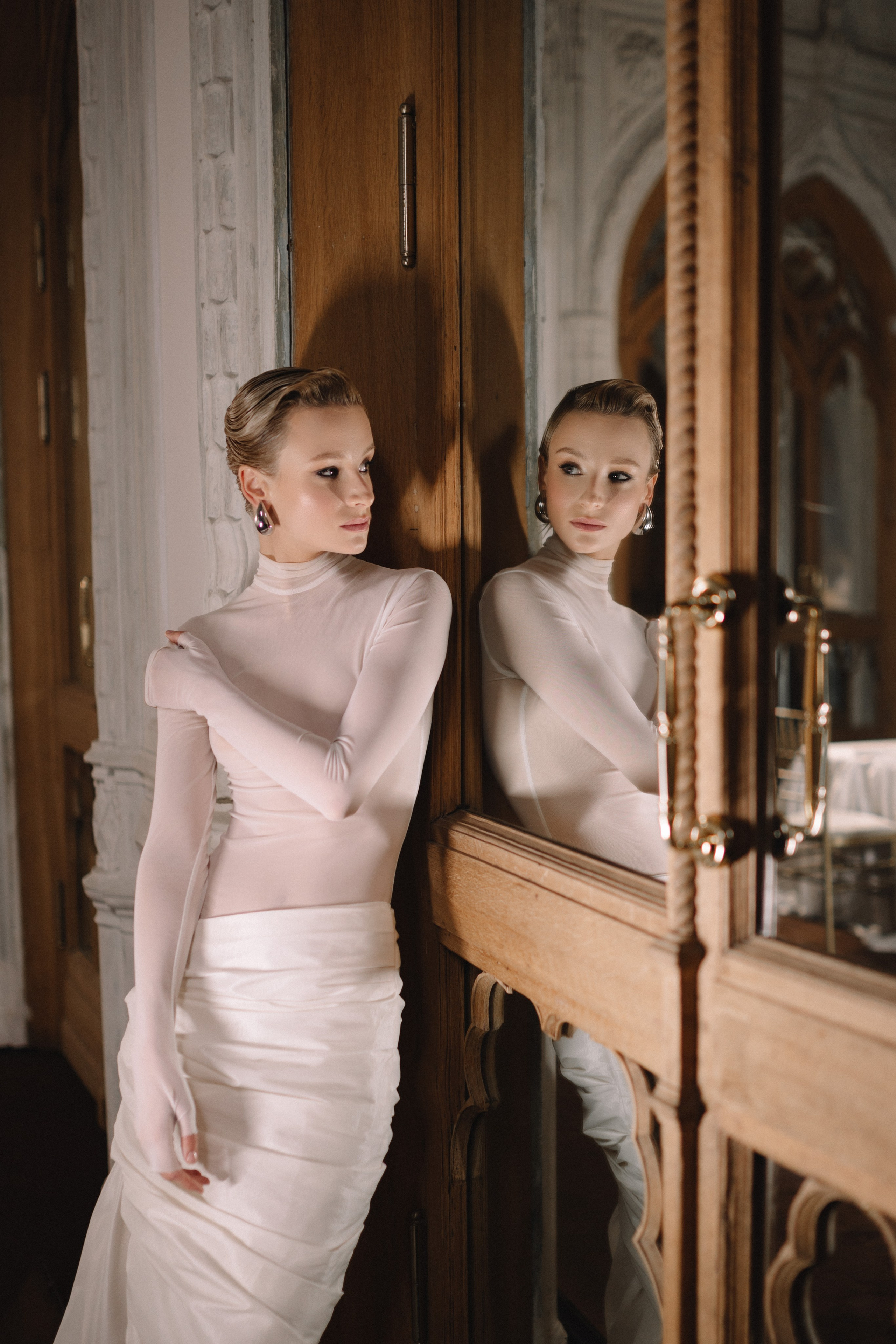 Небрежно опершись спиной на мраморную балюстраду, невеста нежно улыбается своему жениху.