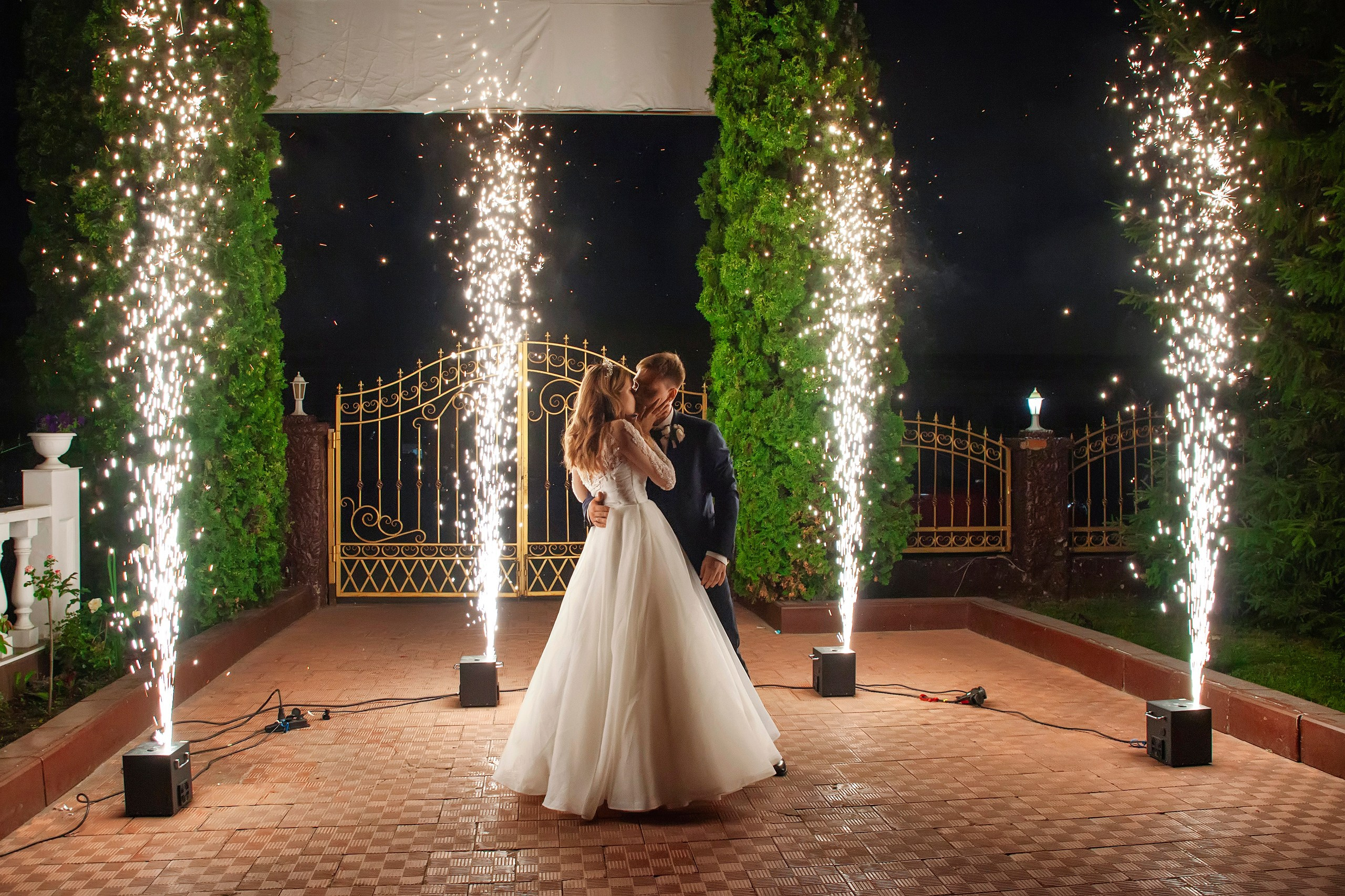 Жених с невестой на фоне холодных фонтанов во дворе ресторана