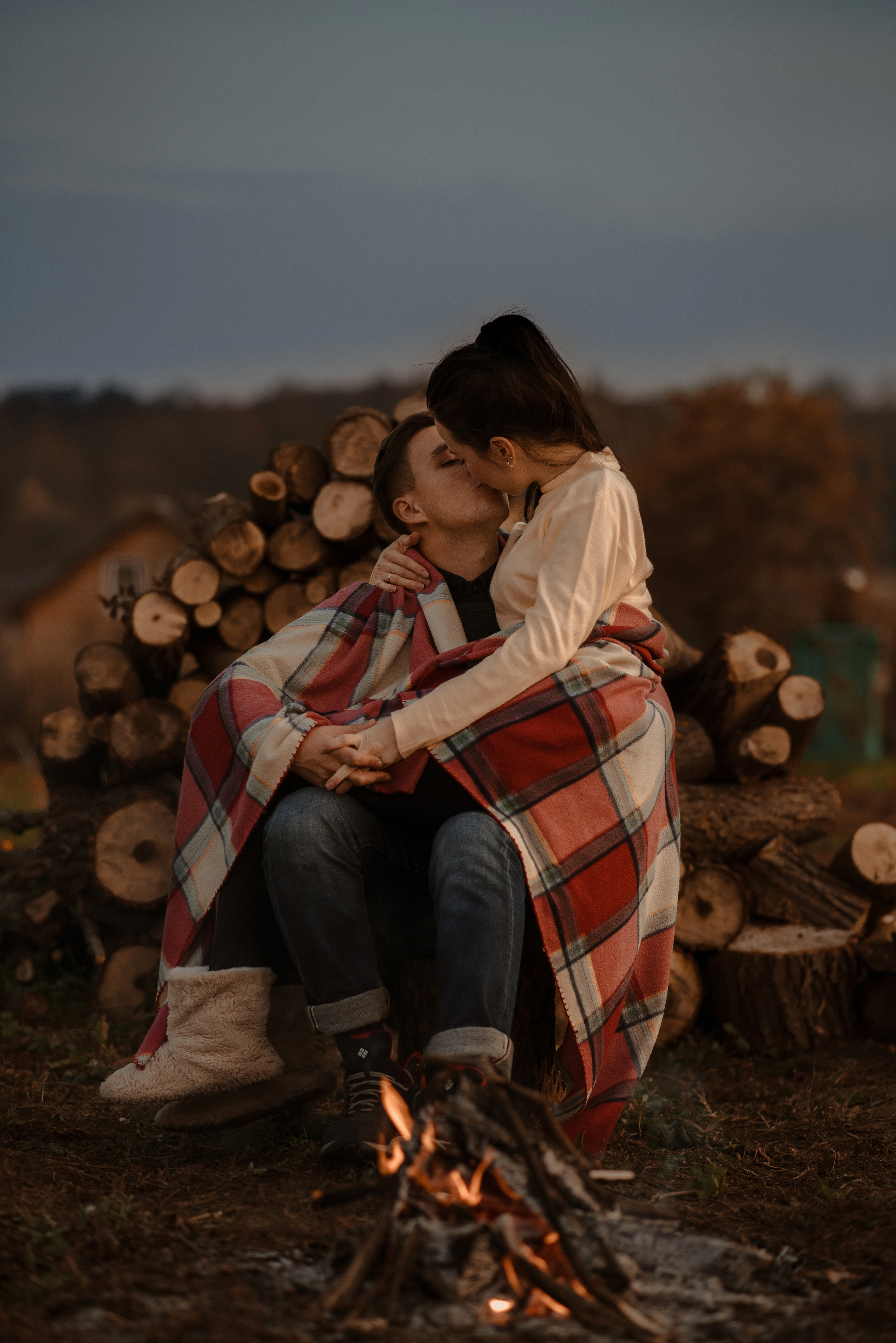 Уютная фотосессия пары у костра в пледе на фоне дров. Love Story. 