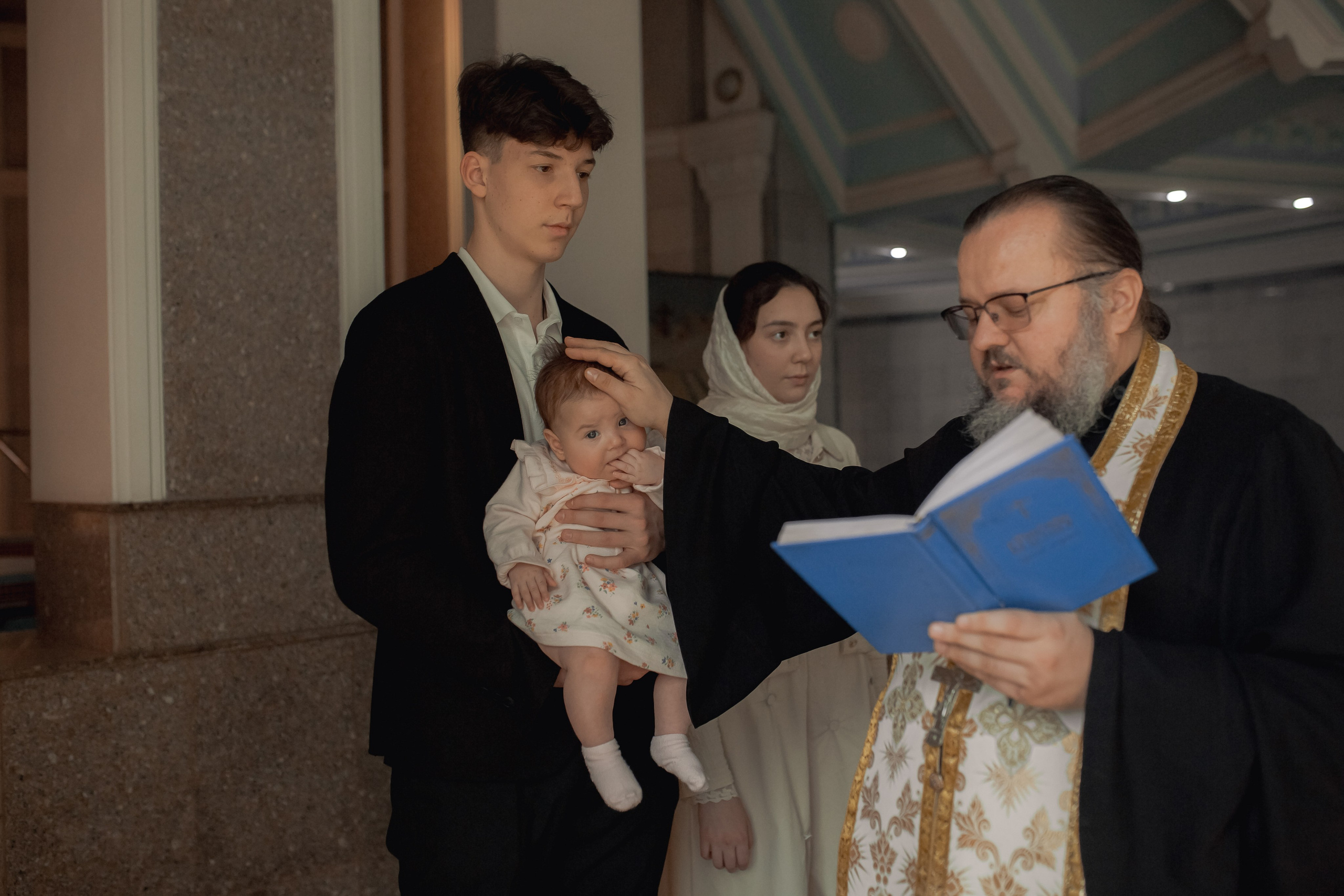 иеромонах Михаил (Столяров), который проводит огласительные беседы в Ташкенте, совершает помазание ребенка